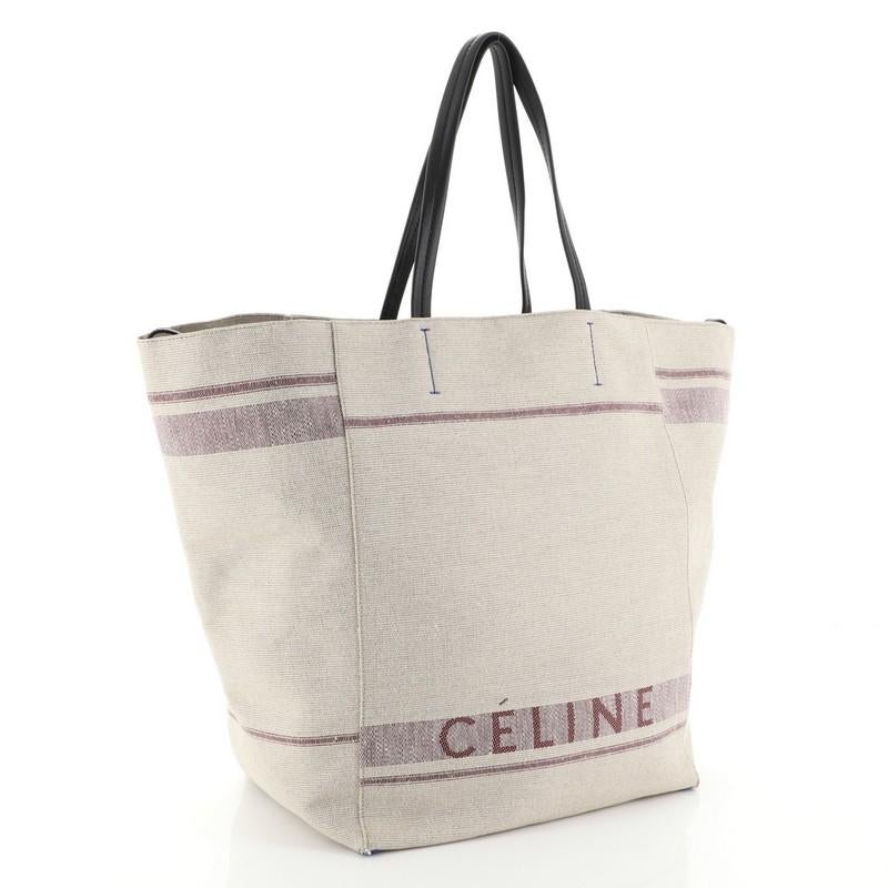 This Celine Phantom Cabas Tote Canvas Small, crafted in neutral canvas, features dual slim leather handles, extended side ties, and gold-tone hardware. It opens to a neutral canvas interior. 
Estimated Retail Price: $1,850
Condition: Very good. Wear