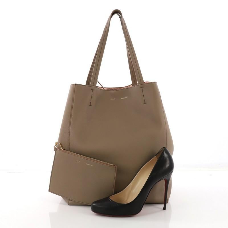 This Celine Phantom Cabas Tote Leather Large, crafted in beige leather, features dual slim leather handles, stamped Celine logo, and gold-tone hardware. It opens to a rose metallic interior with side zip and slip pockets. **Note: Shoe photographed
