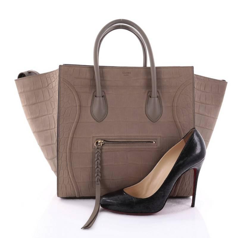 This authentic Celine Phantom Handbag Crocodile Embossed Nubuck Medium is one of the most sought-after bags beloved by fashionistas. Crafted from beige crocodile embossed nubuck leather, this minimalist tote features dual-rolled handles, an exterior