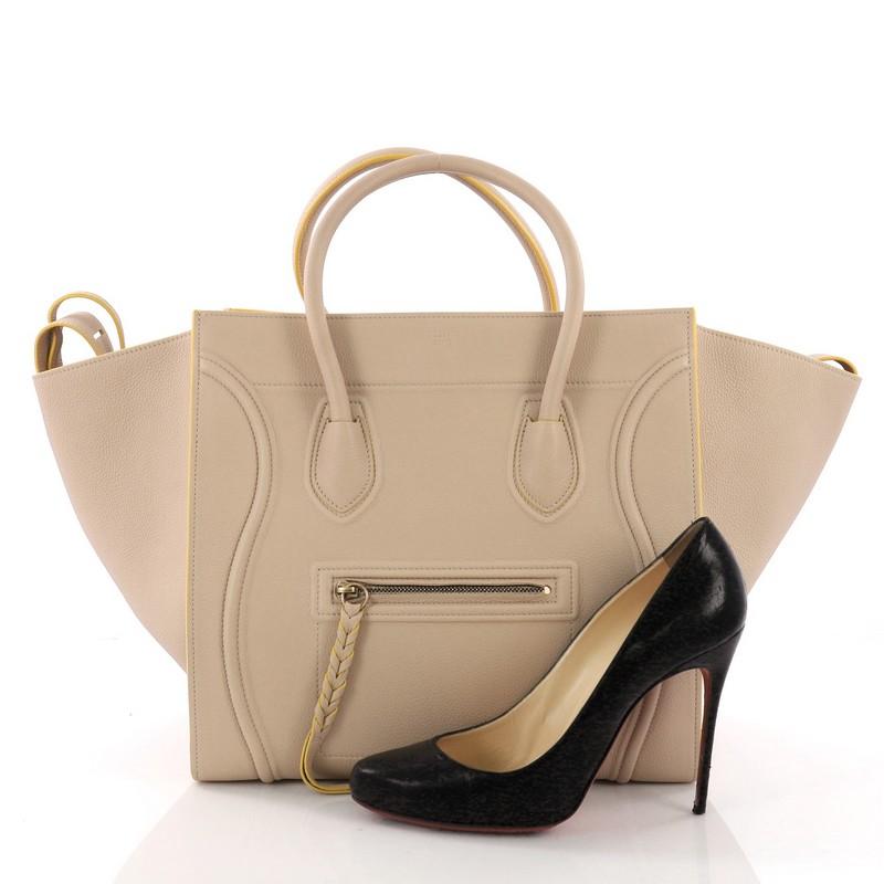 This Celine Phantom Handbag Grainy Leather Medium, crafted in nude grainy leather, features dual rolled leather handles, front zip pocket, and aged gold-tone hardware. It opens to a yellow suede interior with zip pocket. **Note: Shoe photographed is