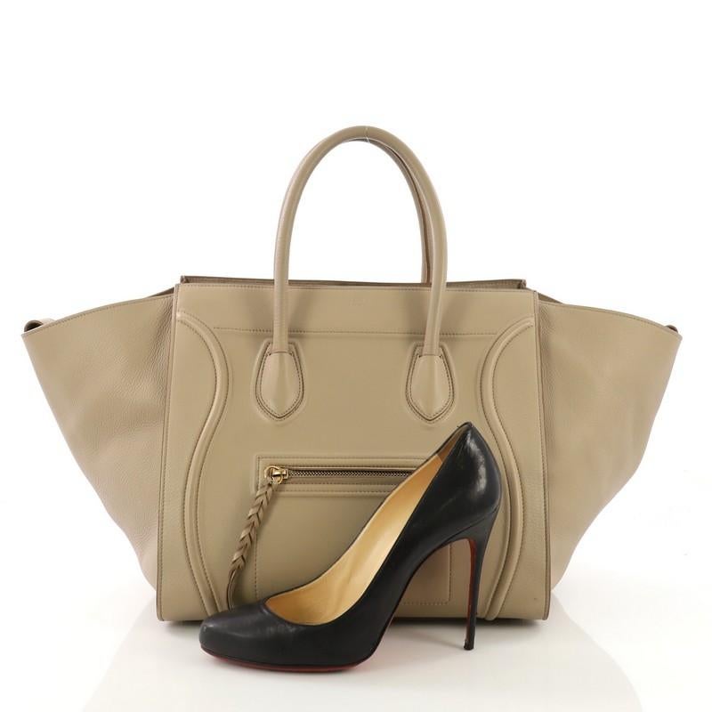 This Celine Phantom Handbag Smooth Leather Medium, crafted in beige smooth leather, features dual rolled handles, front zip pocket, and aged gold-tone hardware. It opens to a beige suede interior with side zip pocket. **Note: Shoe photographed is