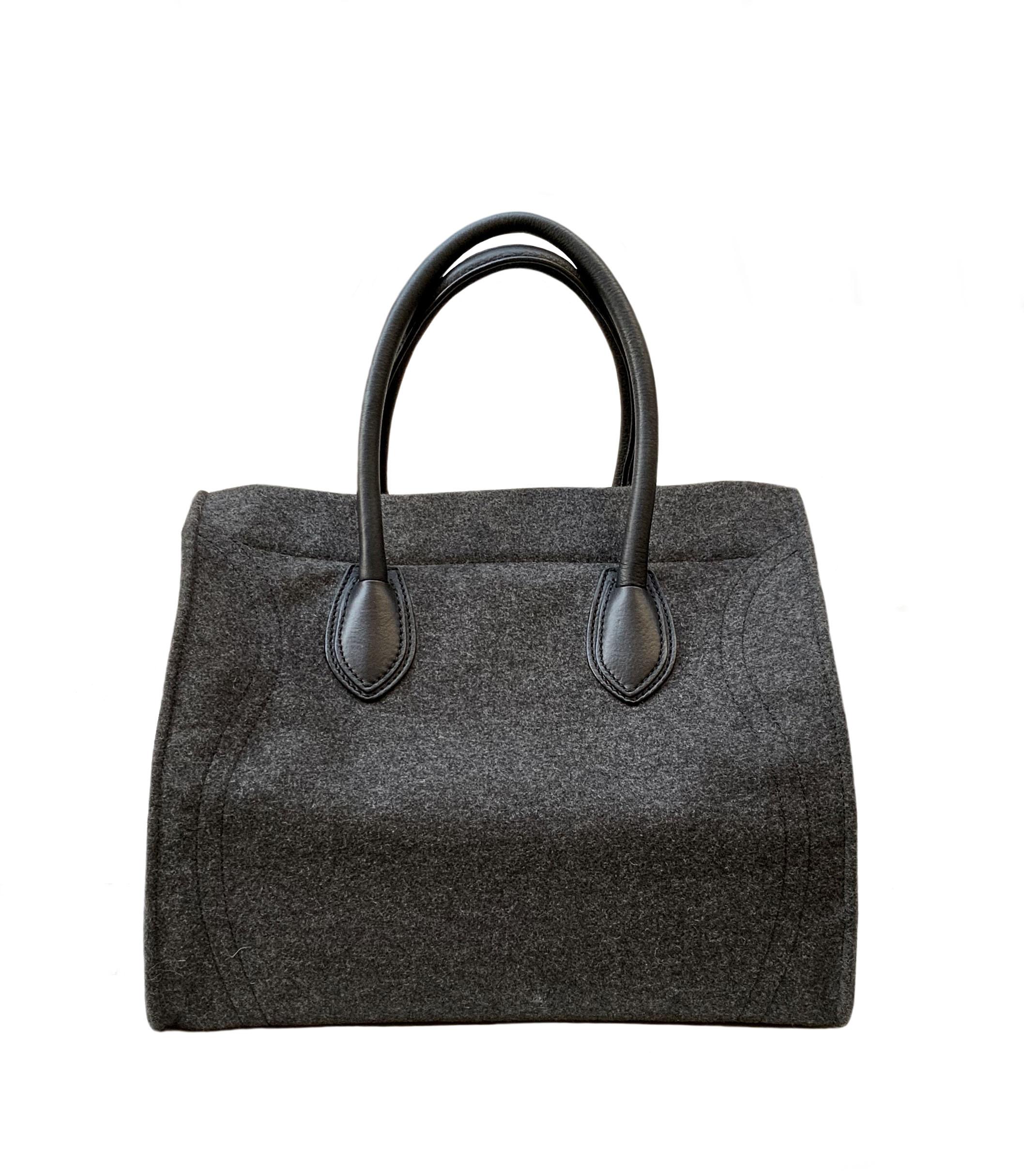 This pre-owned Celine Phantom Luggage tote bag is crafed in grey felt wool. 
It features double rolled handles with detailing stitching, one front zip pocket.
Its line is simple, its color discreet and its weight ultra-light !
A must for this season