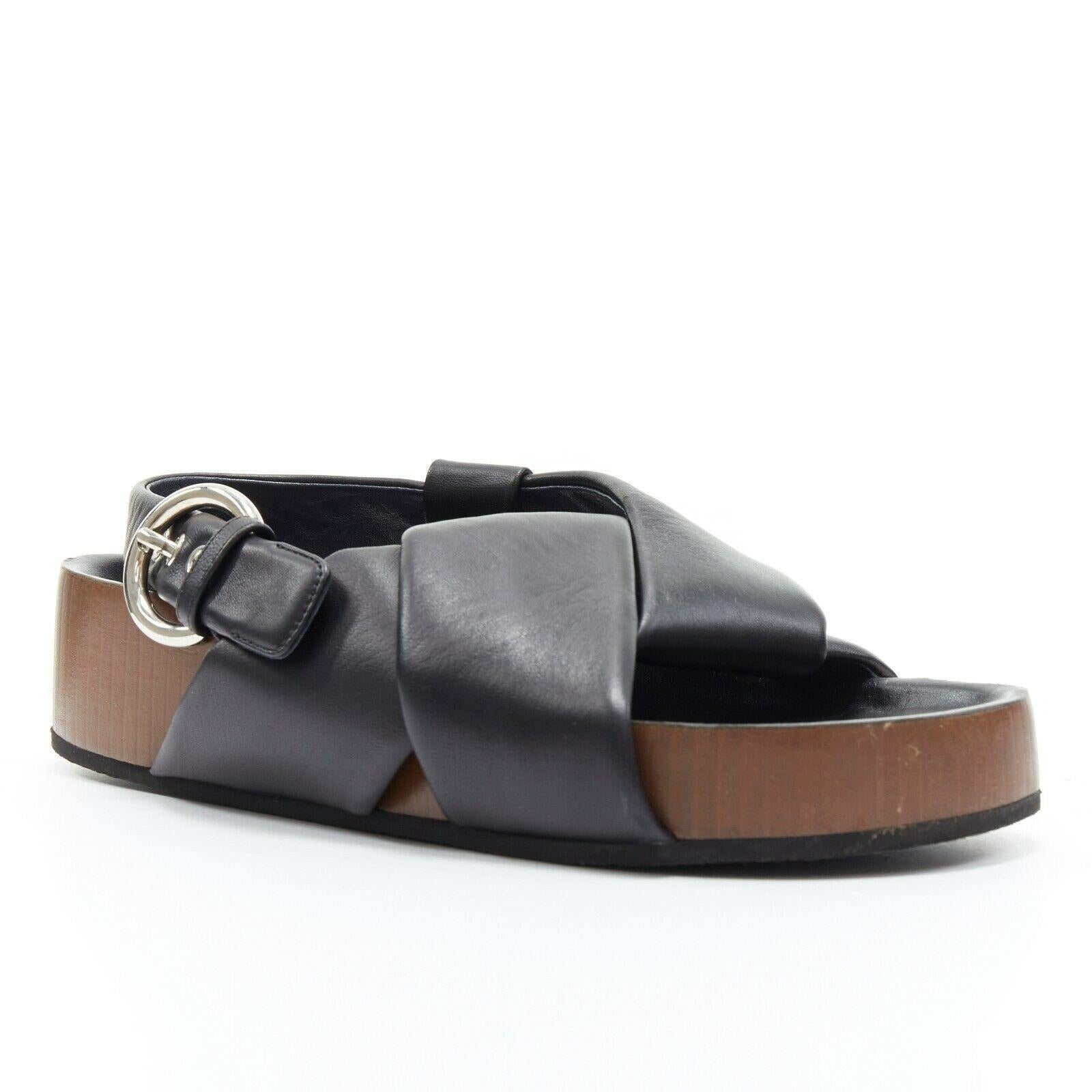 CELINE PHOEBE PHILO black padded leather twist slides slingback sandals EU38

CELINE BY PHOEBE PHILO
Black padded leather. Origami twist upper strap. Open toe. Dark brown
vertical stripe textured leather sole. Leather lining. Moulded footbed. Thick