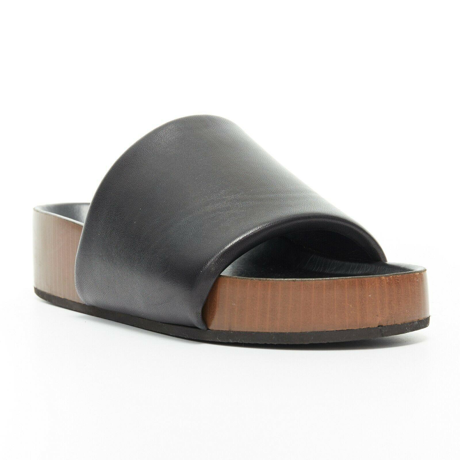 CELINE PHOEBE PHILO Boxy black padded leather thick band thick sole slides EU37

CELINE BY PHOEBE PHILO
Boxy sandals. Black lightly padded leather upper. Thick single strap. Open toe. Moulded black leather covered footbed. Brown faux wood print