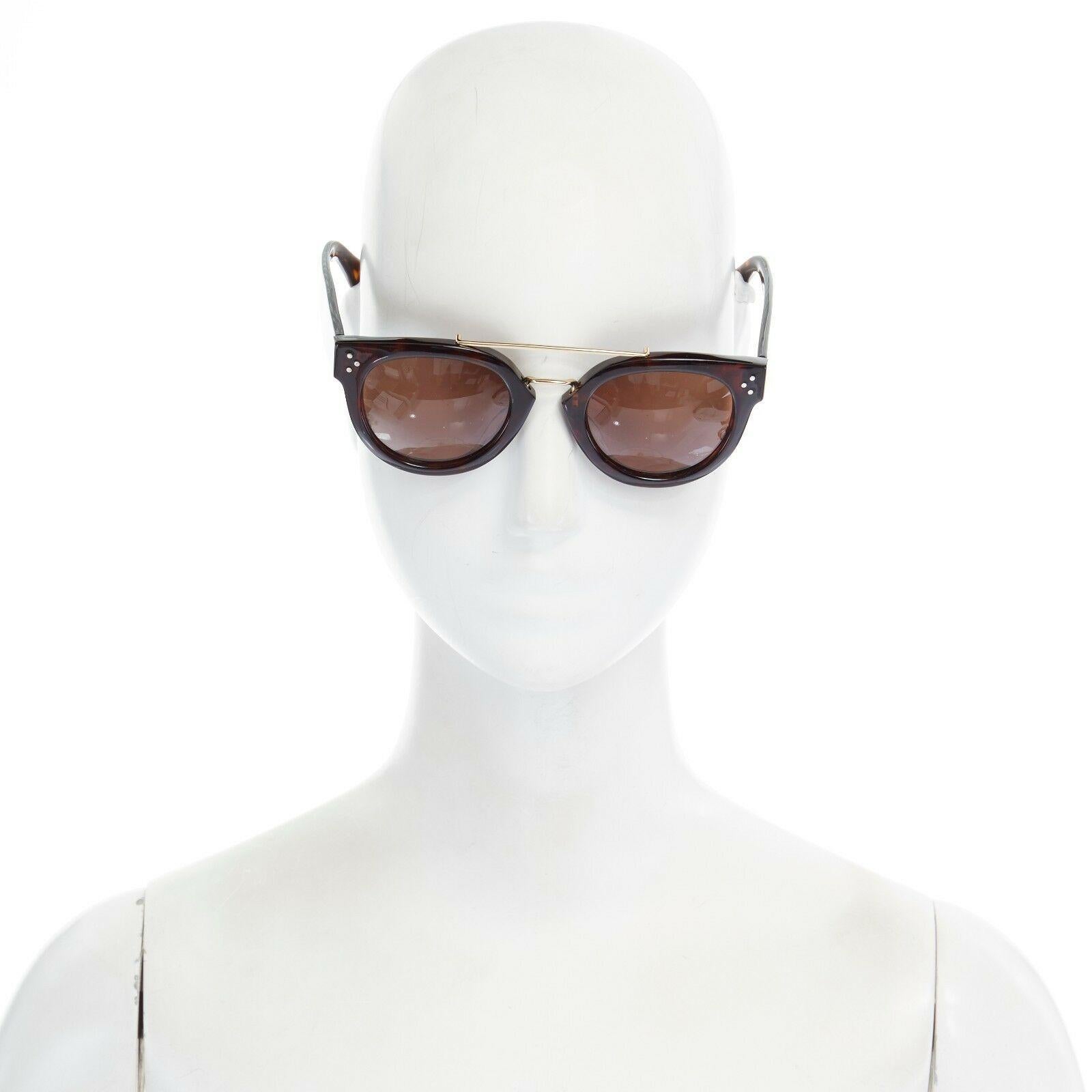 CELINE PHOEBE PHILO brown acetate thick frame browbar brown lens sunglasses

CELINE BY PHOEBE PHILO
Brown tortoiseshell acetate. Gold tone accented at brow bar. Signature silver stud detail at temple.  Rounded square shape. Molded nose pads. Thick