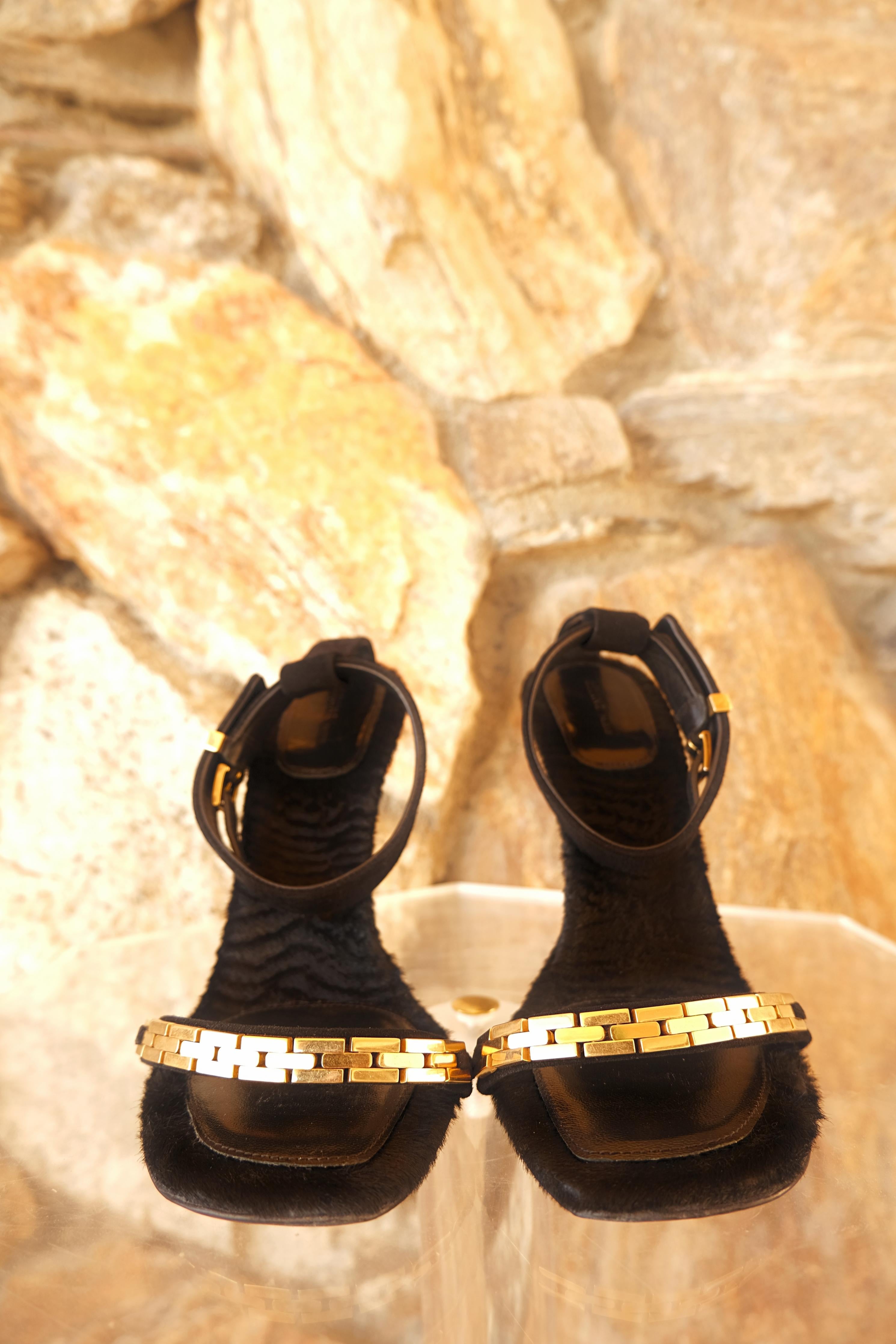 Sandales à brides de cheville en fausse fourrure et daim de Celine, ornées de chaînes et de ferrures dorées.

Talon aiguille.

Bout carré ouvert.

Livré avec sa boîte d'origine.

Condit : En bon état, conforme à l'âge et à l'utilisation.  Il y a