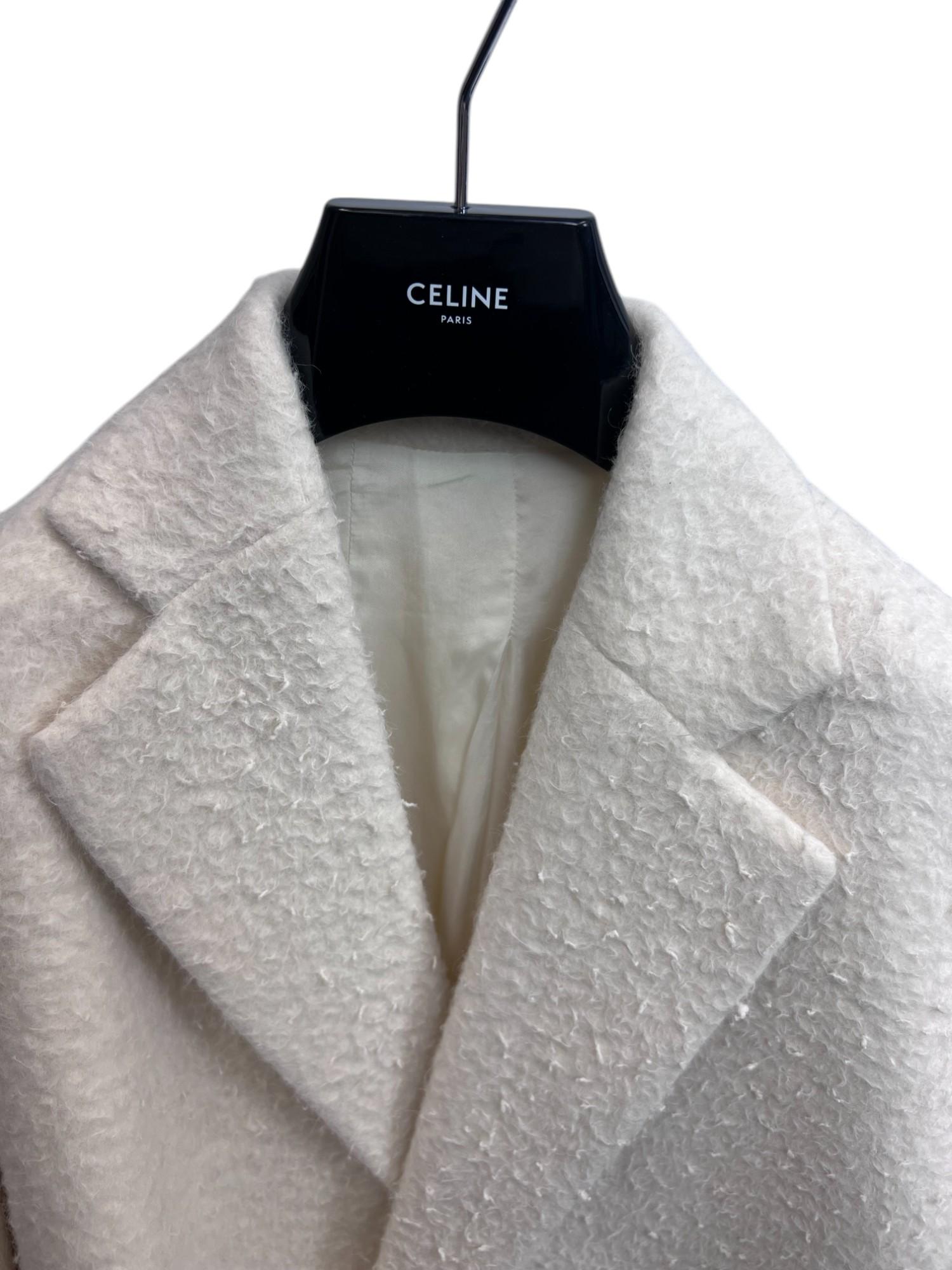 An effortlessly chic and luxurious Celine oversized coat from Phoebe Philo’s era, crafted from a sumptuous off-white alpaca blend. This statement piece showcases minimalist tailoring with a relaxed, oversized silhouette, embodying Philo’s signature