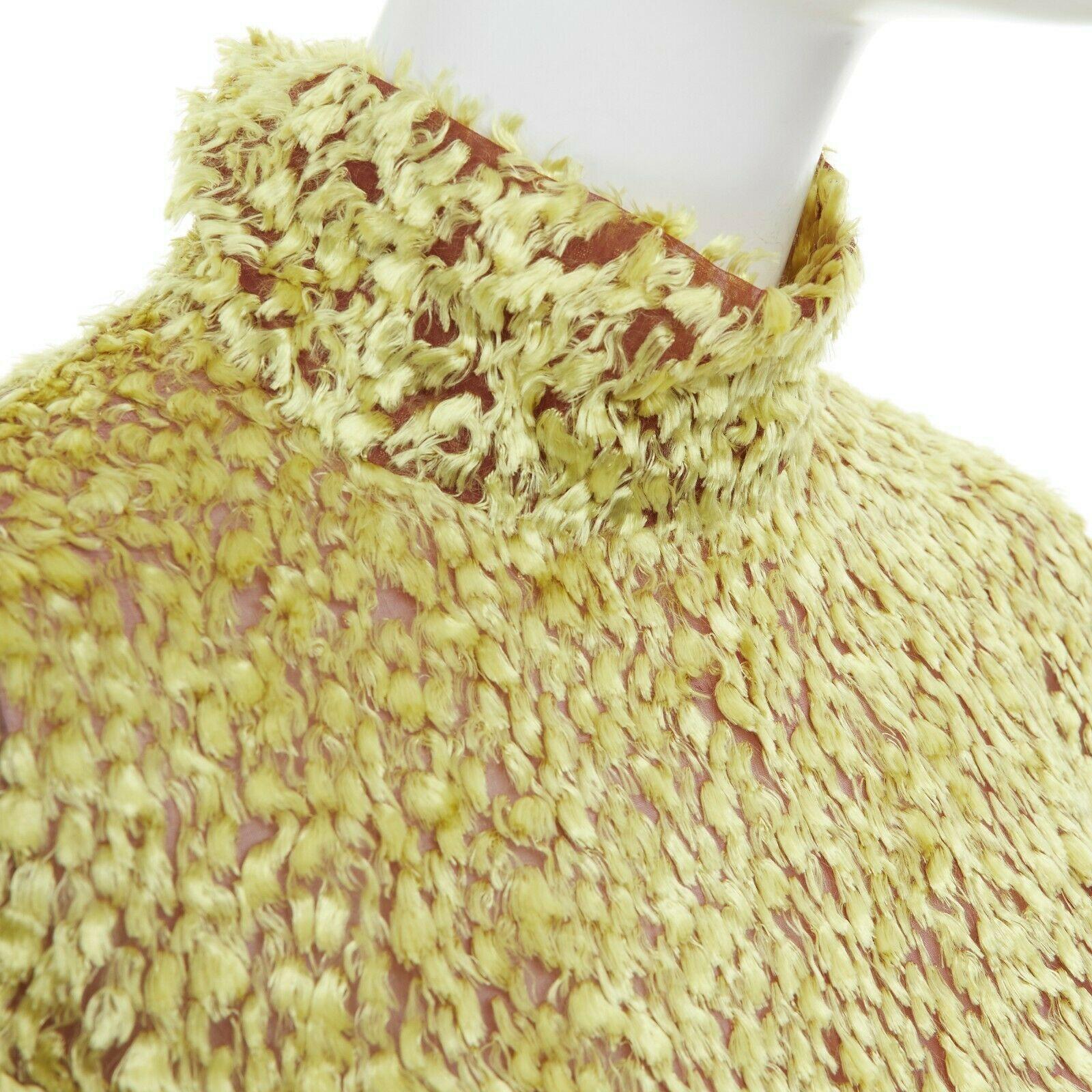 CELINE PHOEBE PHILO yellow fluffy yarn embellished mock neck top FR40 M

CELINE BY PHOEBE PHILO
Viscose, silk. Golden yellow fluffy thread embroidery throughout. Brown mesh lining. Mock collar. Long sleeves. Concealed zip back closure. Made in