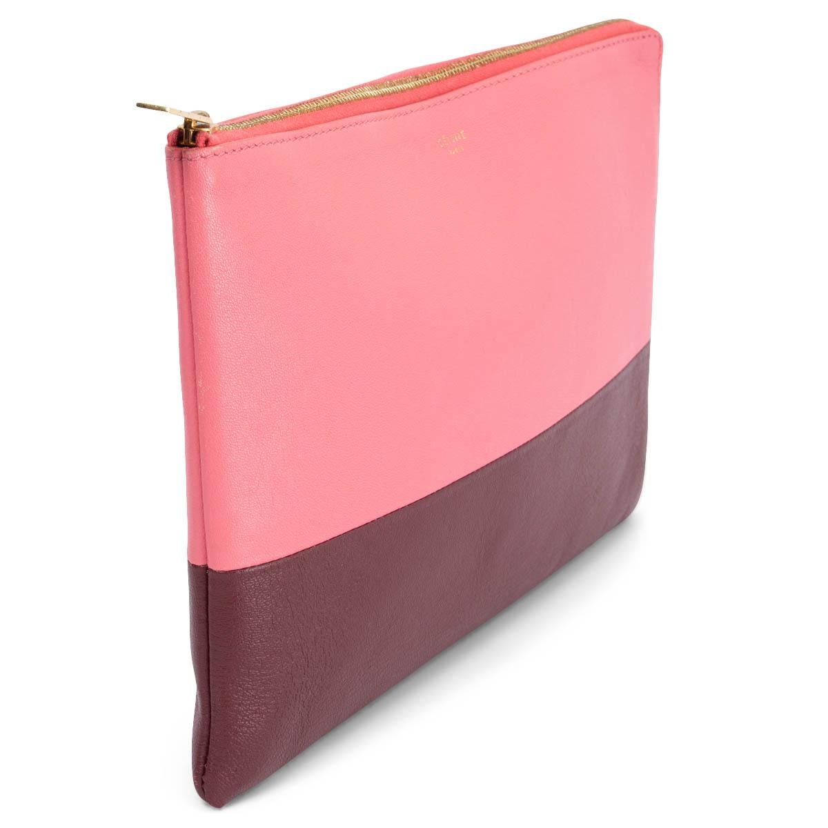 100% authentic Céline Solo pouch in pink and burgundy calfskin with gold-tone zipper. Lined in pink leather. Has been carried and is in excellent condition. 

Measurements
Height	17.5cm (6.8in)
Width	25cm (9.8in)
Depth	1.5cm