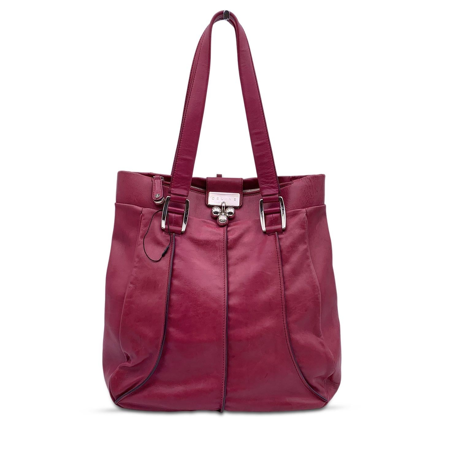 Celine pink leather tote bag. Silver metal hardware. Fold over strap with spheres closure. 1 zip pocket on top. Brown fabric lining. 1 side zip pocket inside. 'Celine' tag inside

Details

MATERIAL: Leather

COLOR: Pink

MODEL: -

GENDER: