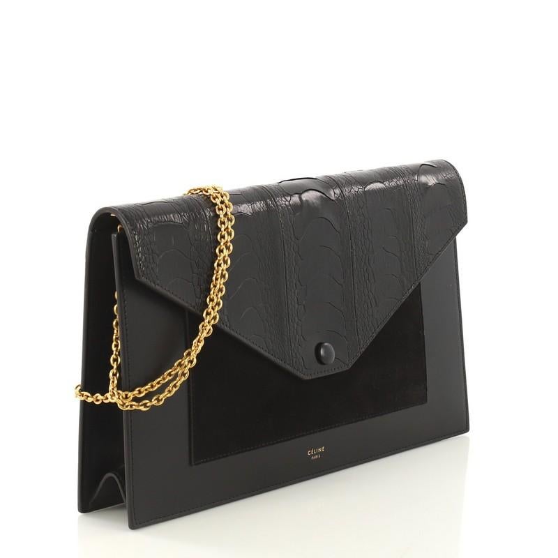 This Celine Pocket Envelope Wallet on Chain Ostrich with Leather and Suede Medium, crafted from genuine black Ostrich with leather and suede, features chain-link strap, envelope flap, stamped Celine logo, and gold-tone hardware. Its snap button