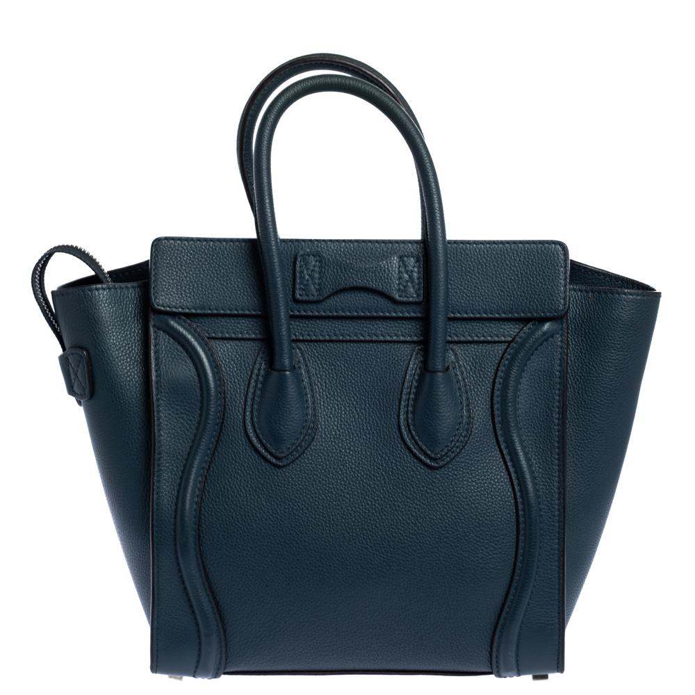 The micro Luggage tote from Celine is one of the most popular handbags in the world. This tote is crafted from leather and designed in a lovely shade of blue. It comes with rolled top handles, metal feet at the bottom, and a front zip pocket. The