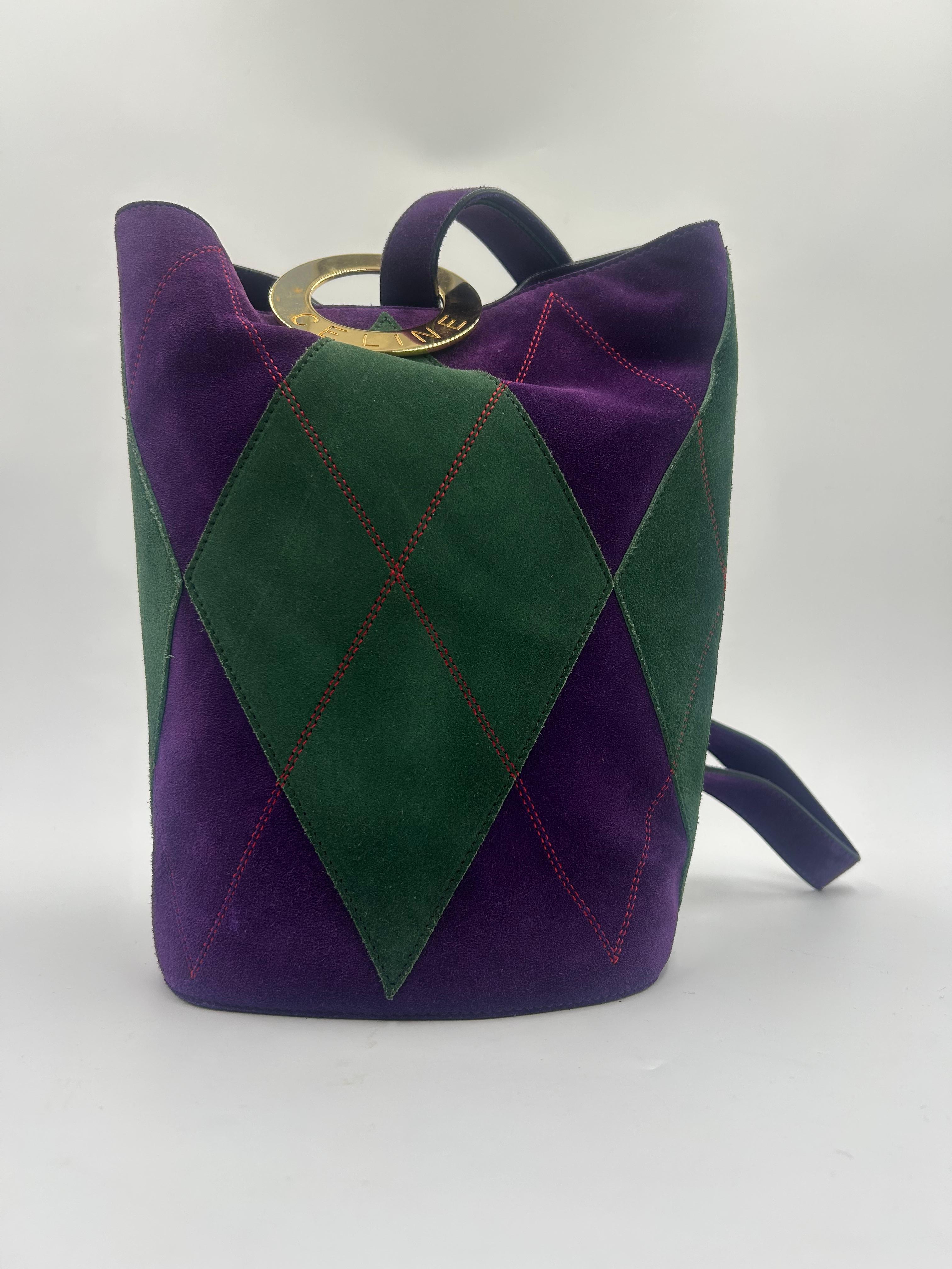 The bag in the image is a Celine Trapeze Bag, a now-iconic silhouette from the Phoebe Philo era of Celine. It features a structured, architectural design with a distinctive trapezoidal shape, narrow at the top and flaring out with extended winged