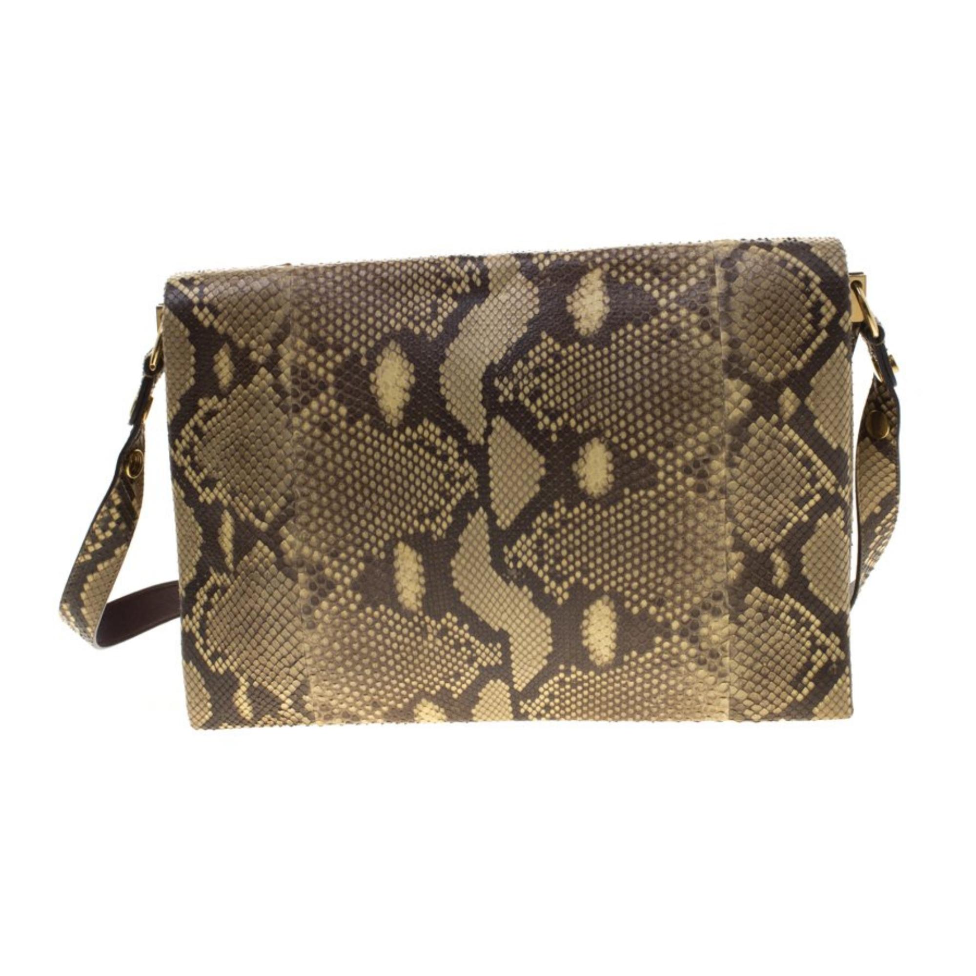 This exotic blade shoulder bag from Celine is made of python leather and features a large front flap, a gold tone bar and magnetic closure. The bag is finished with a partitioned leather interior with an open compartments and zip compartment. Year: