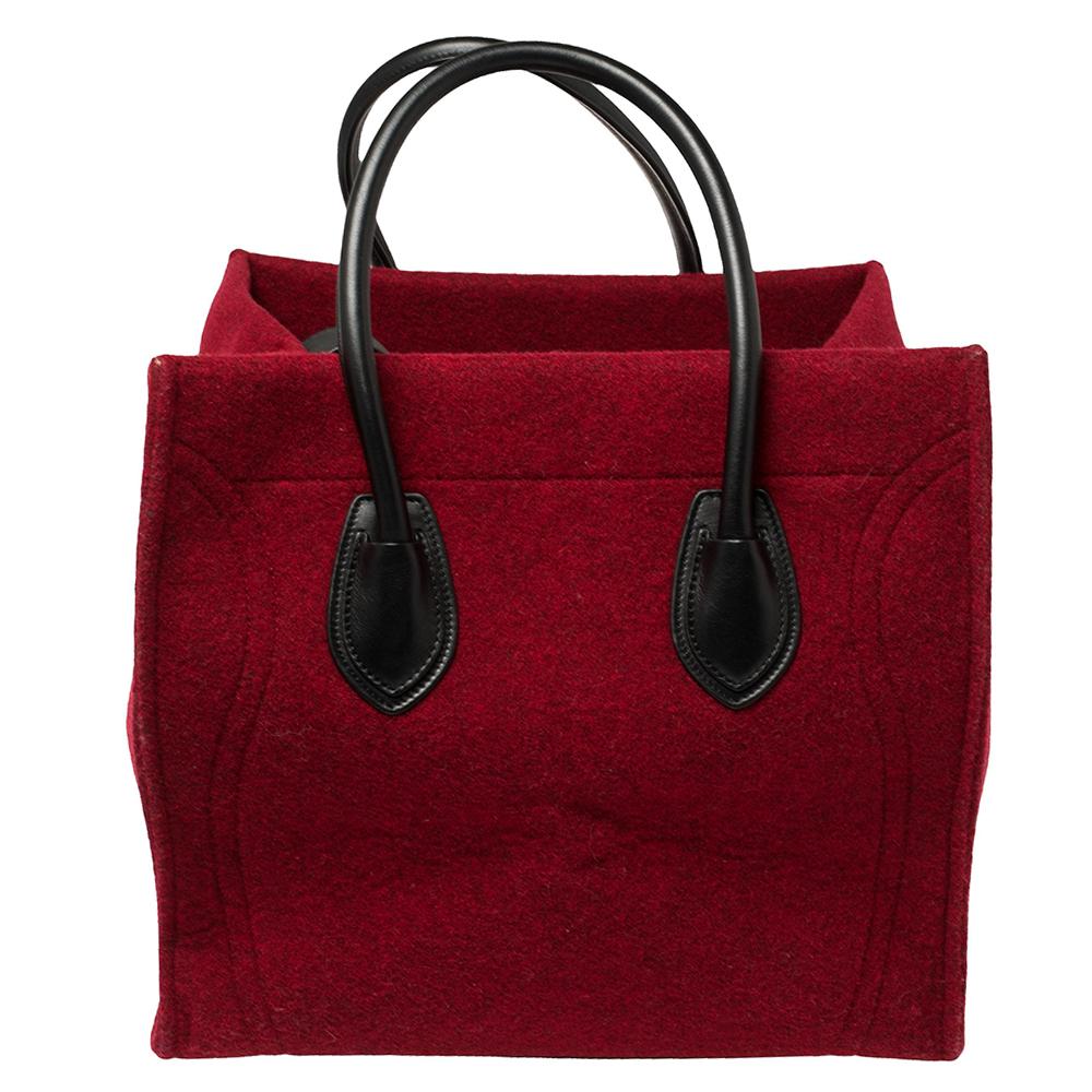 Celine released the Phantom as a newer version of their successful Luggage model. Unlike the Luggage toes, the Phantom has an open top, wider wingspans, and a braided zipper pull. We have here the one in red wool and black leather. It has two top