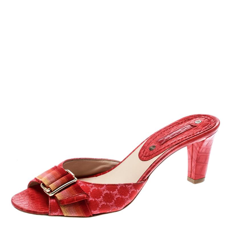 Make an impressive style statement in these gorgeous Celine sandals! The red sandals have been crafted from croc-embossed leather and fabric and styled in an open toe silhouette. They flaunt a buckle strap detailing on the vamps and come equipped