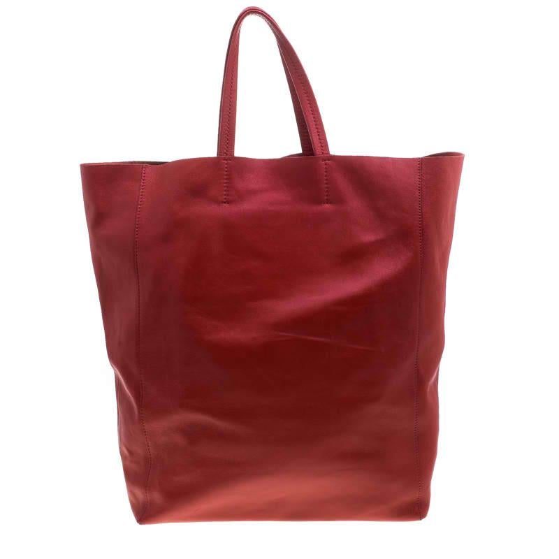 An elegant tote designed by Celine, this Cabas bag is a wonderful mix of fashion and function. Beautifully crafted with red leather into a minimalist yet utilitarian design, the tote features two flat handles and a roomy interior lined with leather