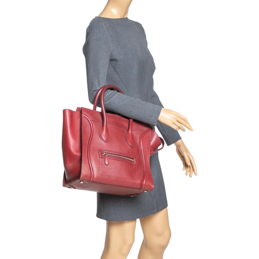 The mini Luggage tote from Celine is one of the most popular handbags in the world. This tote is crafted from leather and designed in a red shade. It comes with rolled top handles and a front zip pocket. The bag is equipped with a well-sized leather