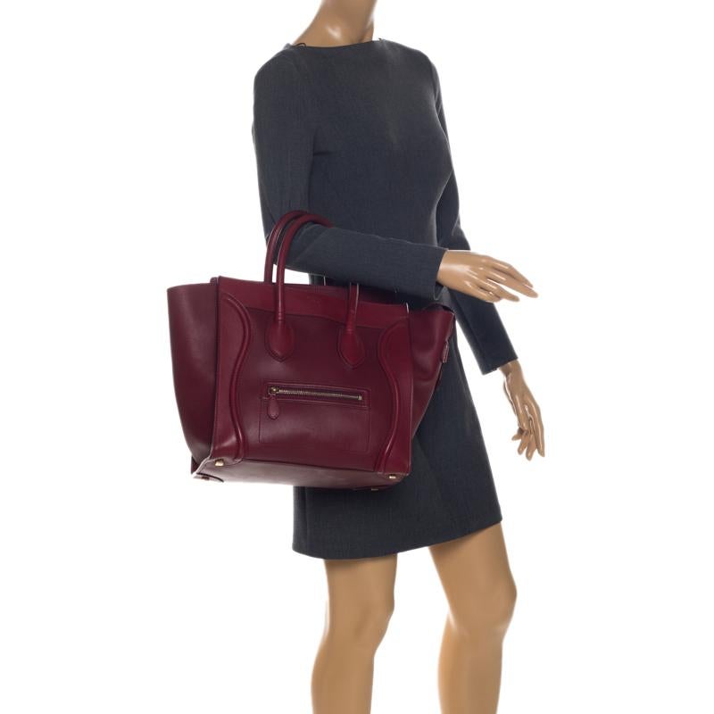 The mini Luggage tote from Celine is one of the most popular handbags in the world. This tote is crafted from leather and designed in a red shade. It comes with rolled top handles, protective metal feet and a front zip pocket. The bag is equipped