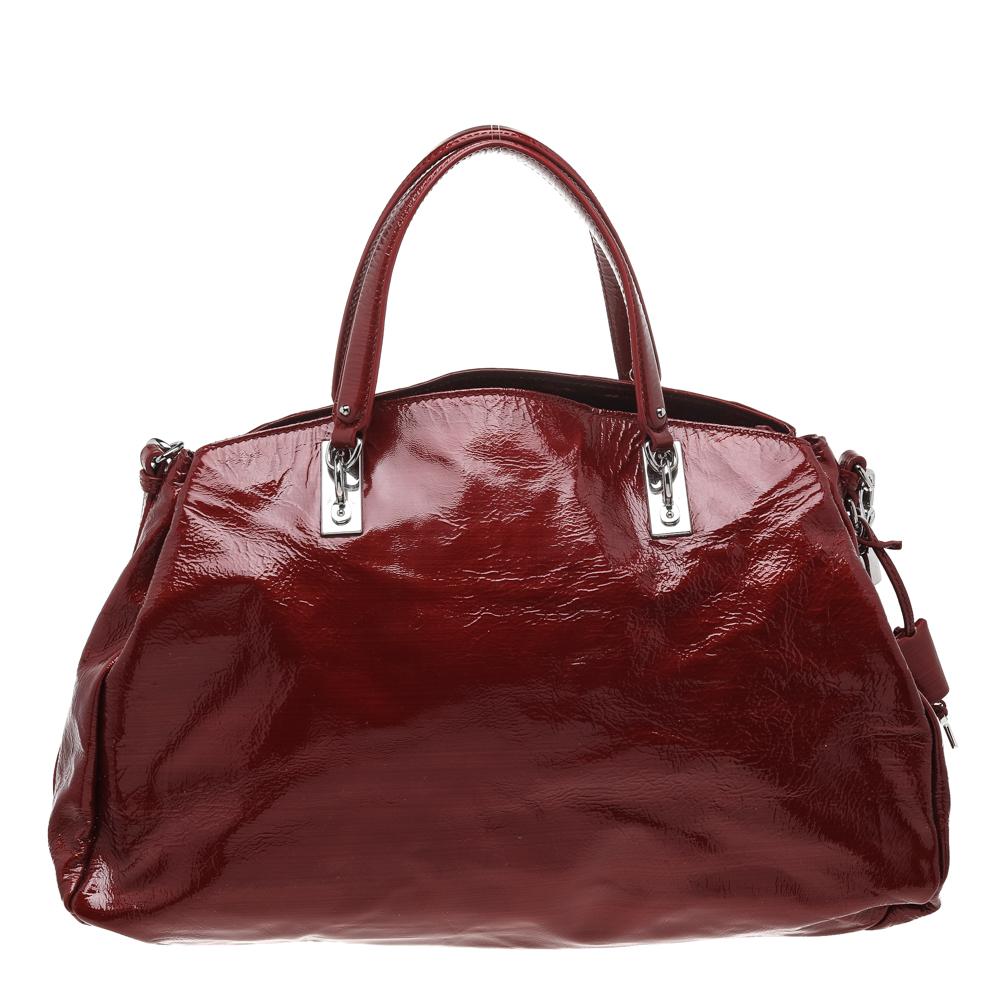 Ce sac de la maison Celine est une création incontournable. Il est conçu en cuir verni rouge et se ferme à l'aide d'un cadenas sur le devant. Il est doté d'une poignée de 12 cm, de ferrures argentées et d'un intérieur spacieux doublé de tissu. Ce