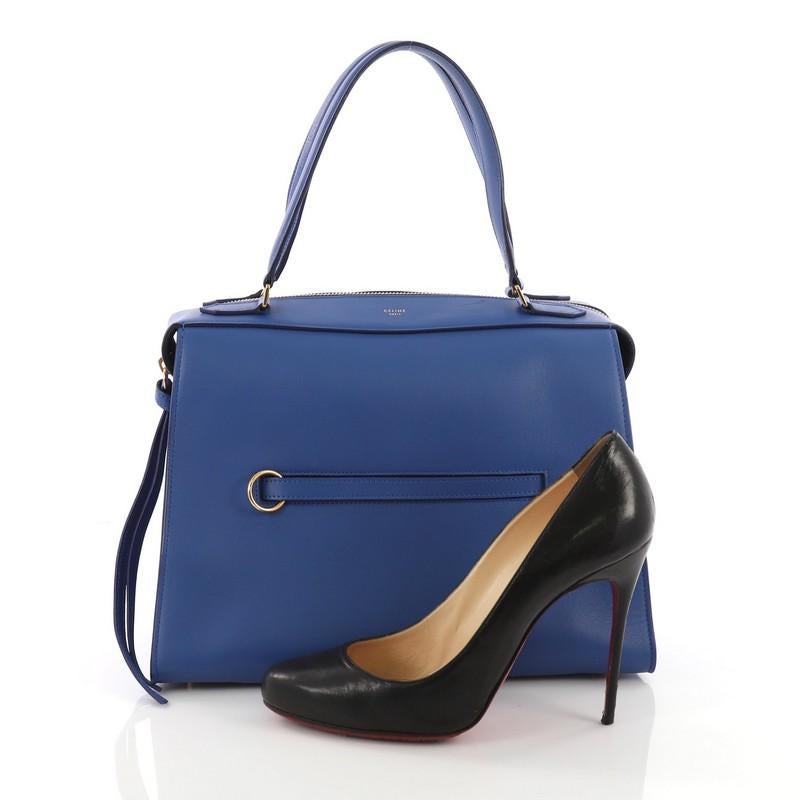This Celine Ring Bag Leather Medium, crafted inblue leather, features tall leather handles, ring accents on its front pocket and gold-tone hardware. Its top zip closure opens to a blue suede interior with side zip and slip pockets. **Note: Shoe
