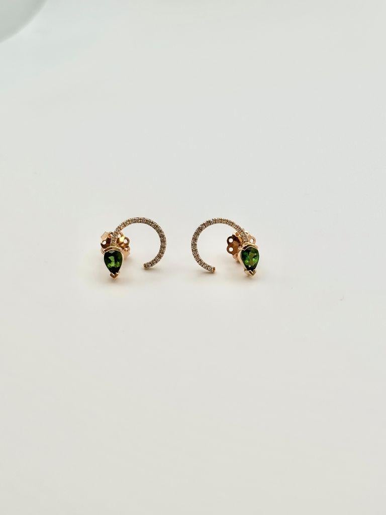 Los pendientes Adeline de una sola curva de Celine Roelens son piezas elegantes y esculturales elaboradas en oro rosa de 18 quilates. Cada pendiente presenta una turmalina verde en forma de pera engastada en un elegante diseño curvo que abraza el