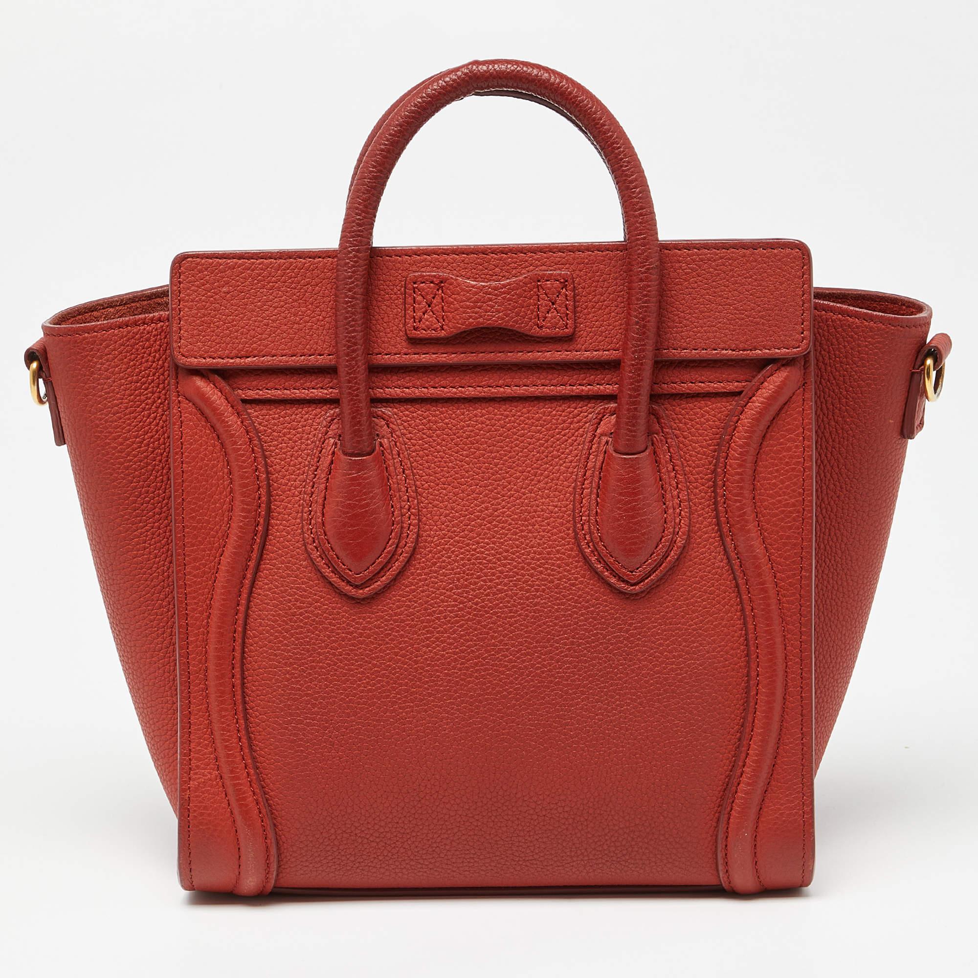 The nano Luggage tote from Celine is one of the most popular handbags in the world. This tote is crafted from leather and designed in a rust brown shade. It comes with rolled top handles and a front zip pocket. The bag is equipped with a well-sized