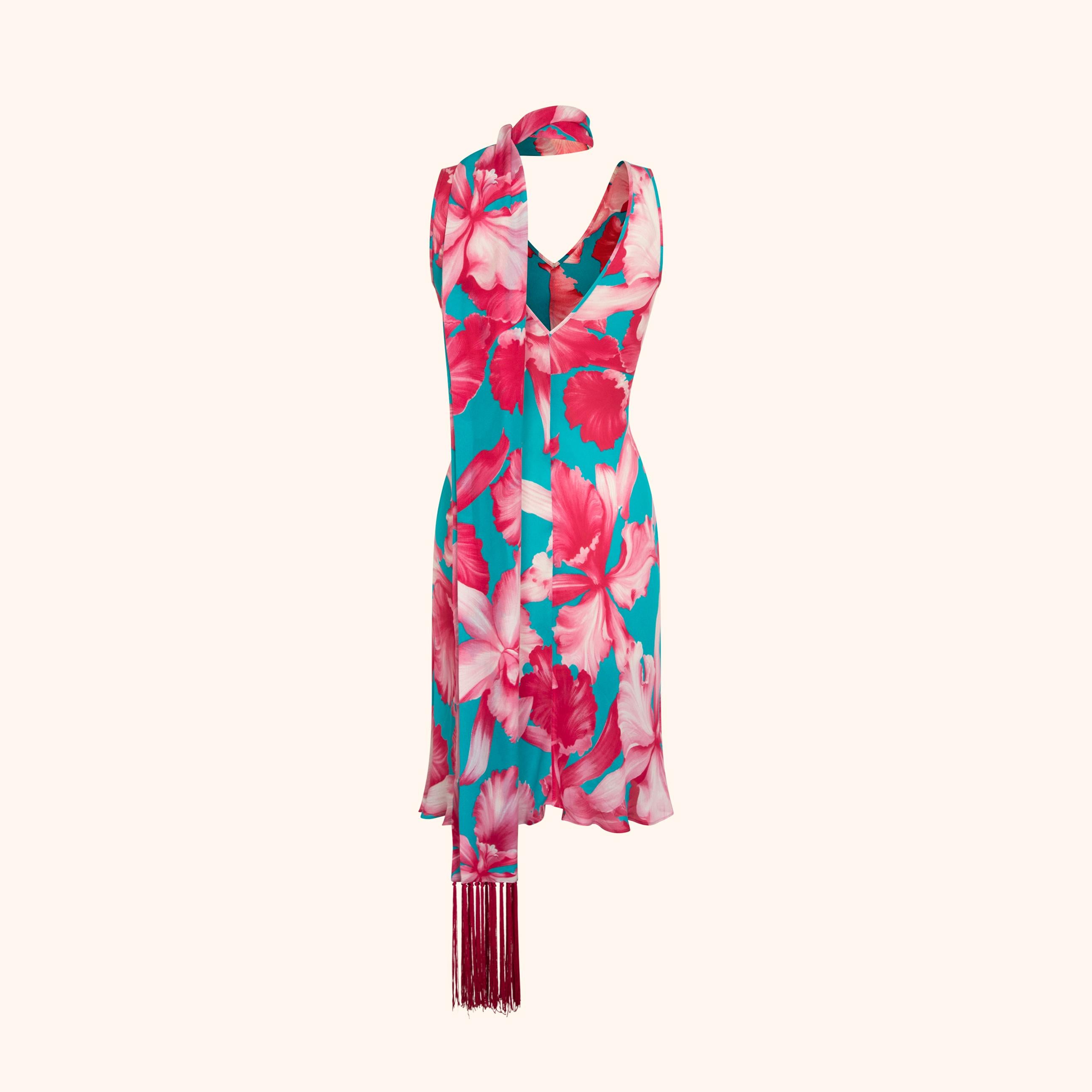 Dieses fließende Kleid aus Seiden-Crêpe, das auf dem Laufsteg zu sehen war, zeigt einen auffälligen, übergroßen Blumenprint in Fuchsia und Elfenbein auf türkisfarbenem Hintergrund. 
Die leicht ausgestellte Silhouette wird mit einem passenden
