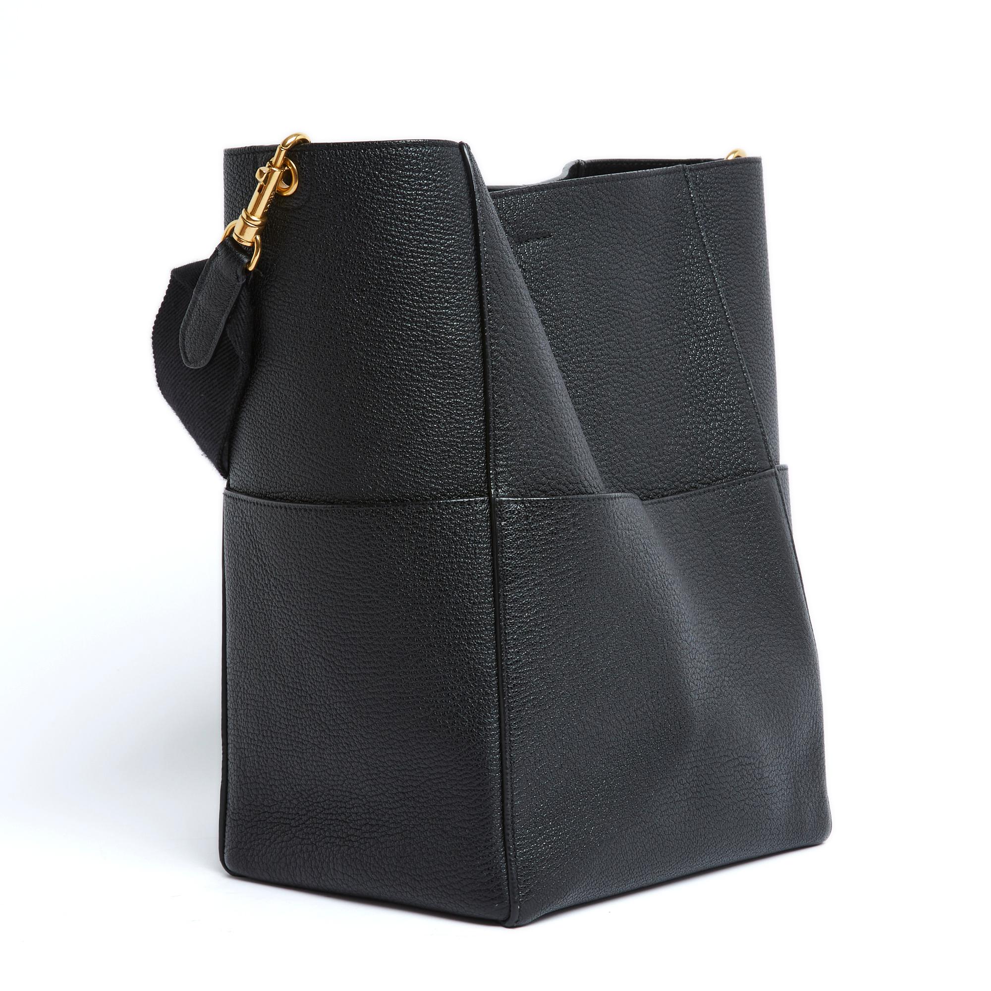 Céline Seau Sangle model bag by Phoebe Philo in black grained leather, unlined, one large front pocket, removable shoulder strap in webbing and matching leather. Width 23 cm x height 32.5 cm x depth 16.5 cm, shoulder strap 60 cm. The bag took a