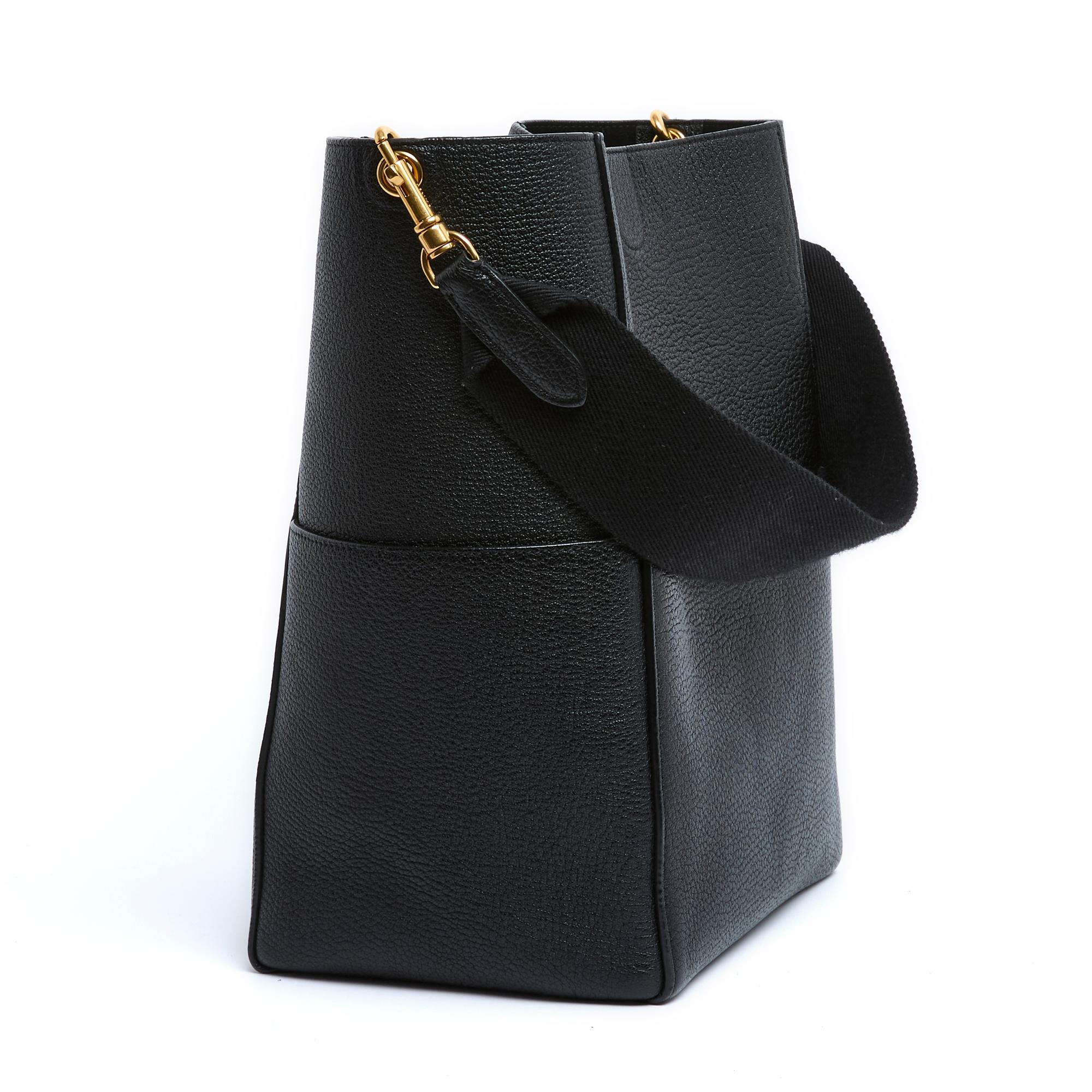 Céline Seau Sangle model bag by Phoebe Philo in black grained leather, unlined, one large front pocket, removable shoulder strap in webbing and matching leather. Width 23 cm x height 32.5 cm x depth 16.5 cm, shoulder strap 60 cm. The bag took a