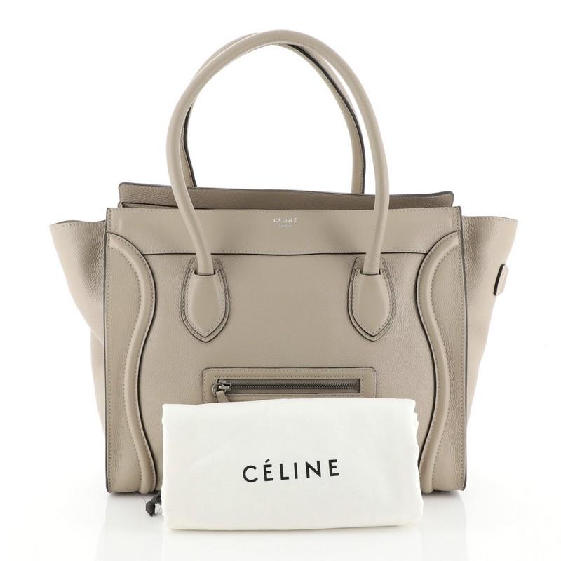 This Celine Shoulder Luggage Bag Leather, crafted from neutral leather, features dual rolled handles, exterior front pocket, protective base studs, and aged silver-tone hardware. Its zip closure opens to a neutral microfiber interior with side zip