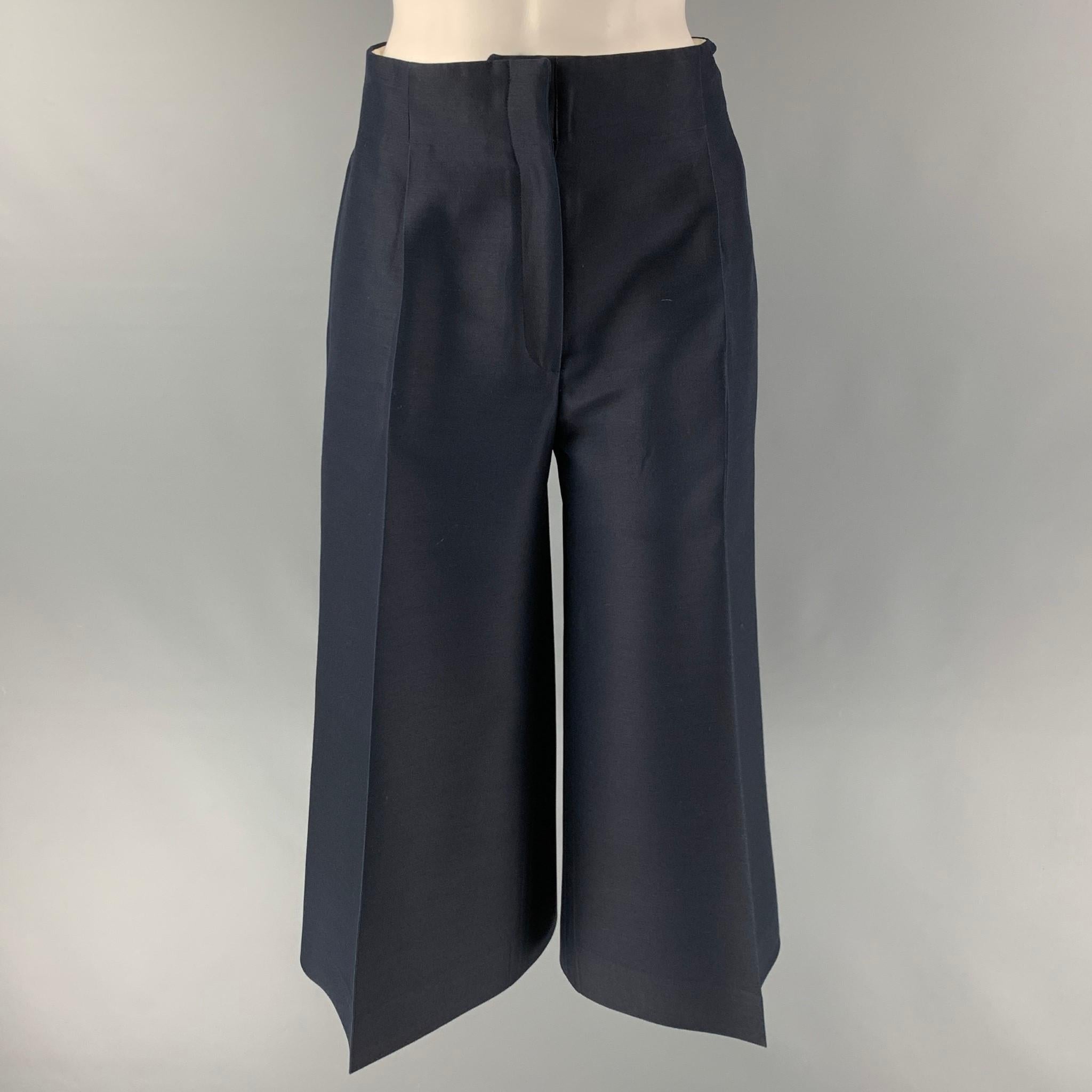 CELINE dress pants comes in a navy wool and silk material featuring a cropped style, wide leg, high waist, a front tab and a zip fly closure. Made in Italy.

Excellent Pre-Owned Condition.
Marked: 36

Measurements:

Waist: 29 in.
Rise: 14
