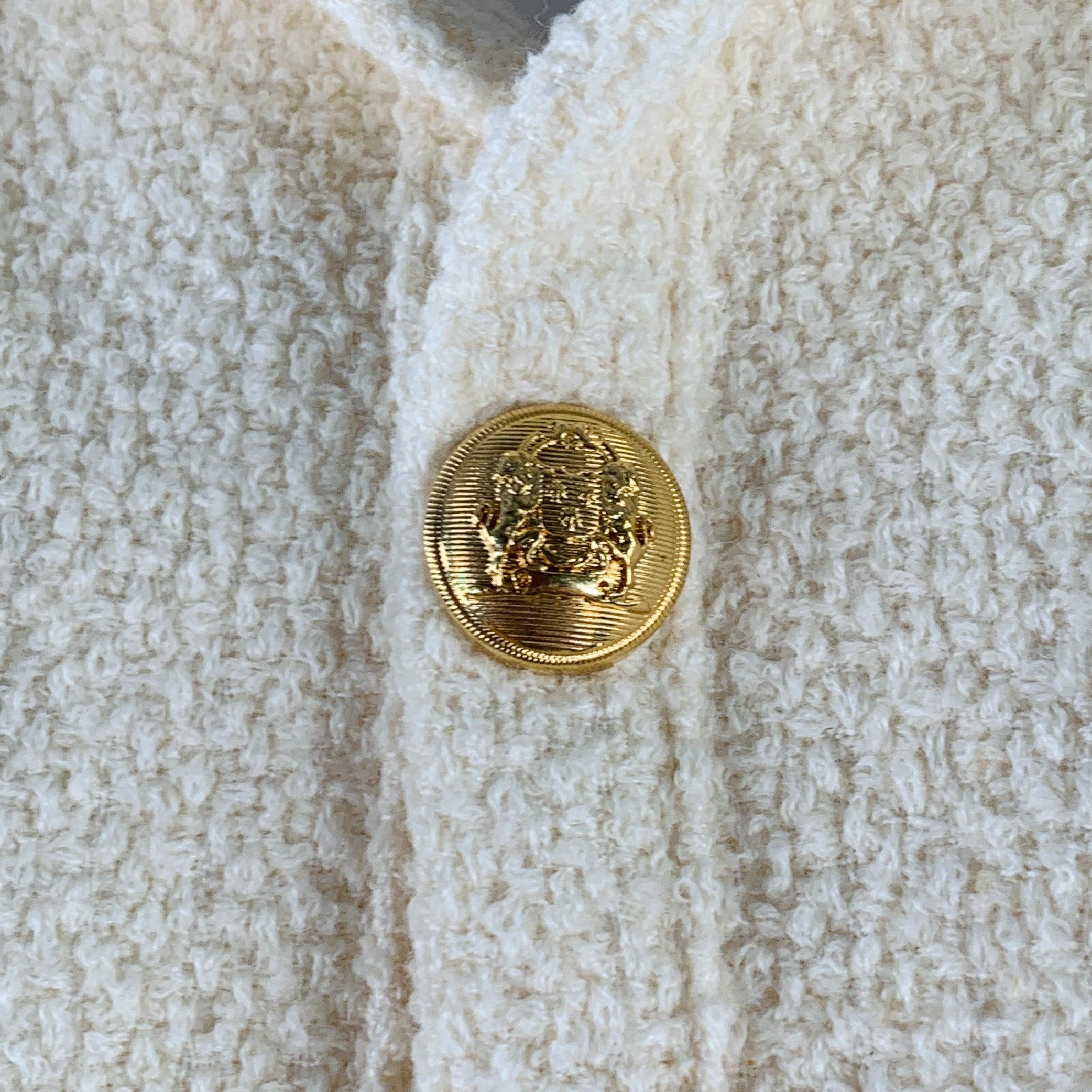 CELINE jacket
in a cream wool polyamide blend boucle featuring short sleeves, two snap pockets, and snap closure with gold tone metal crest buttons.
Made in France.Excellent Pre-Owned Condition. 

Marked:   FR 40 

Measurements: 
 
Shoulder: 14.5