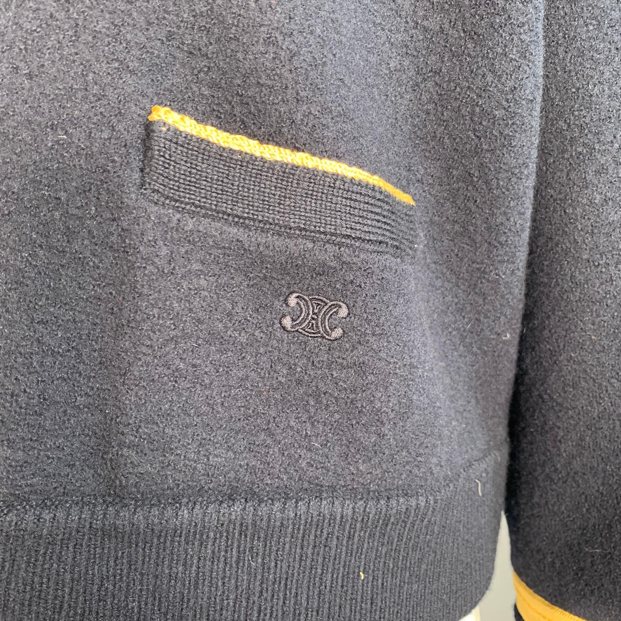 CELINE PARIS sweater
in a
navy wool featuring a contrast gold tone trim, military style with epaulets, oversized boxy fit, and V-neck.Excellent Pre-Owned Condition. 

Marked:   S 

Measurements: 
 
Shoulder: 19.5 inches Bust: 54 inches Sleeve: 20.5
