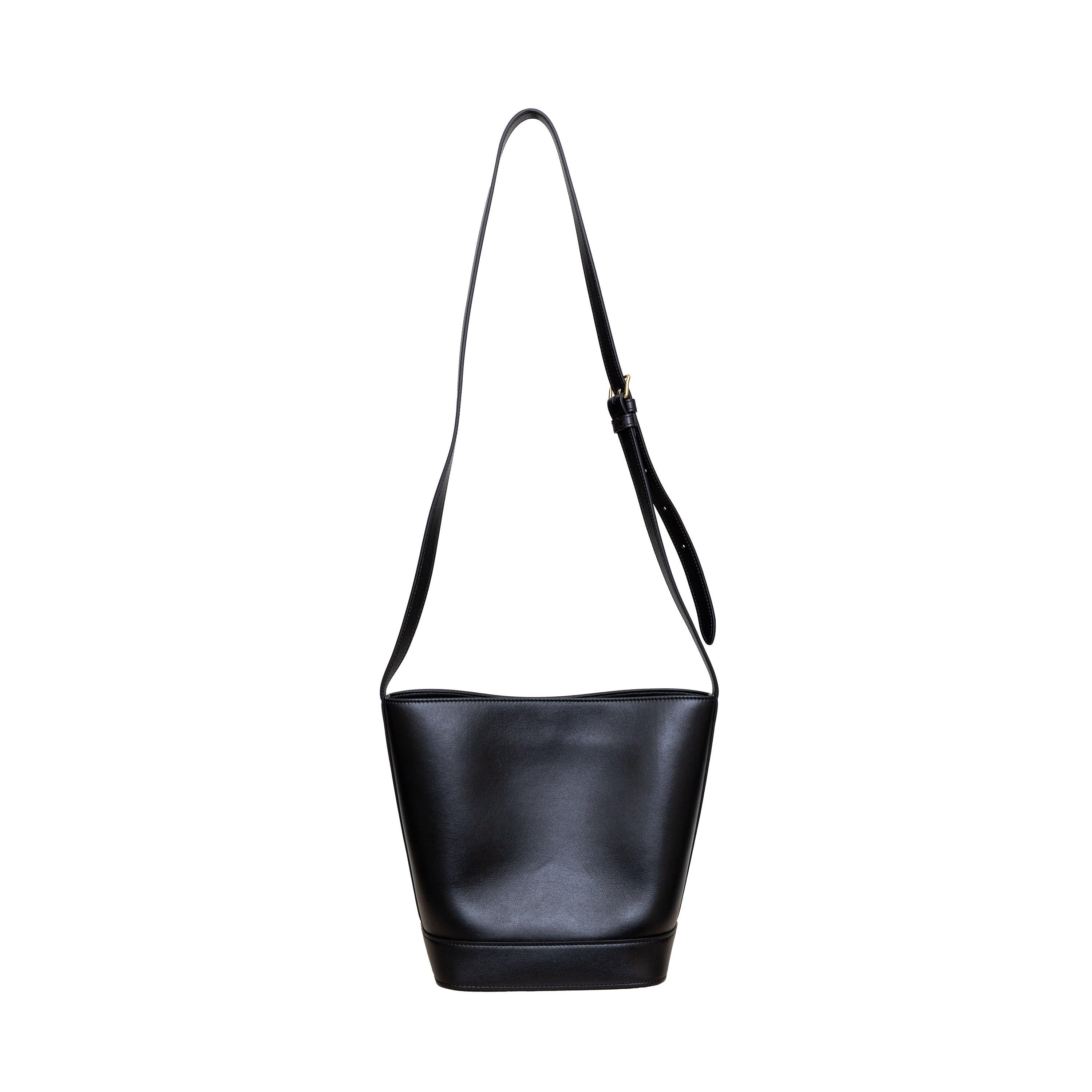 Wir stellen die Celine Small Bucket Cuir Triomphe Bag vor, die mit ihrem verstellbaren Riemen sowohl über den Körper als auch über die Schulter getragen werden kann. Die aus schwarzem Kalbsleder gefertigte und innen mit weichem Wildleder gefütterte