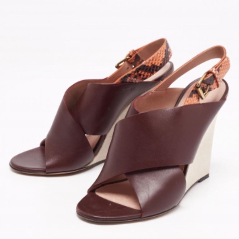 Champion an elegant look with these Celine sandals. Created from snakeskin and leather, they are added with wide criss-cross panels on the uppers, ankle buckle closure, and wedge heels.