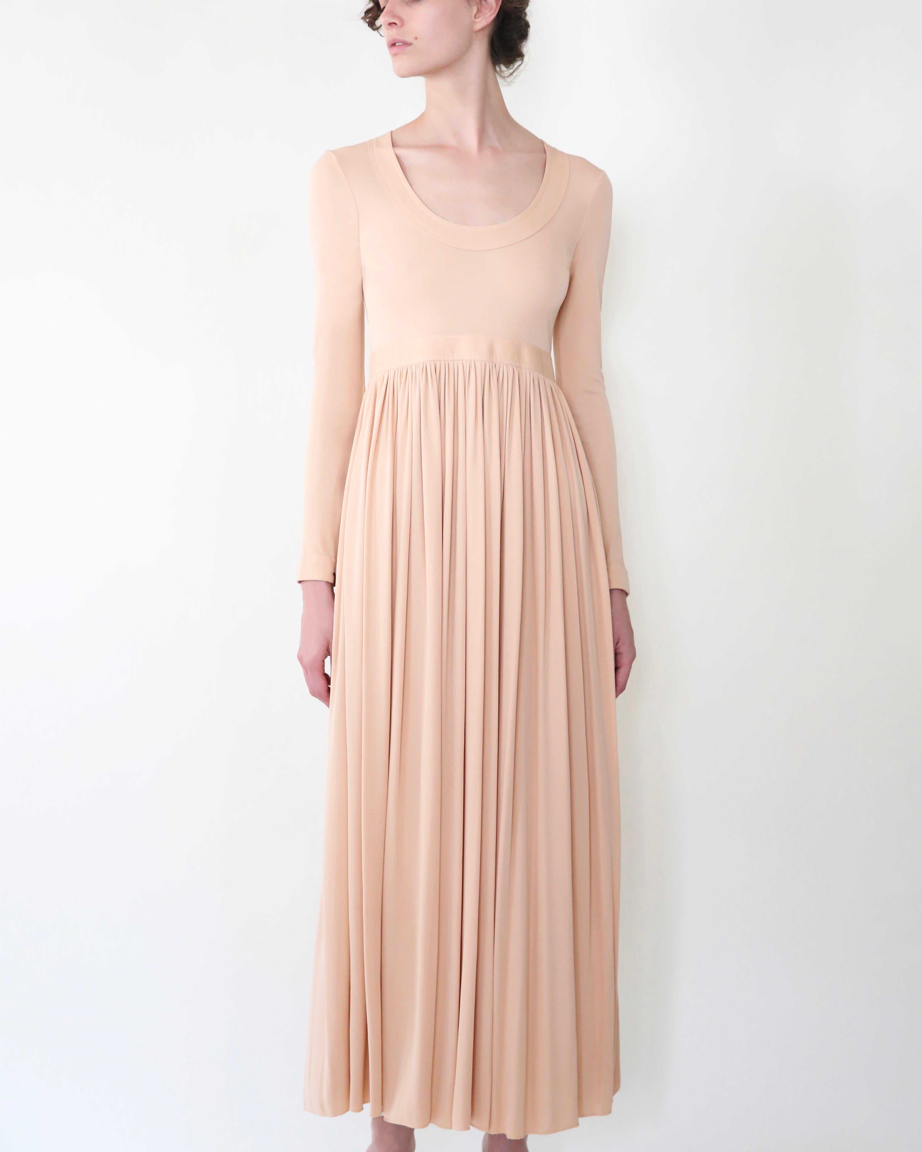 LOVE LALI VINTAGE

A lovely and very feminine midi length dress from Celine Spring 2016 in slinky peach viscose
Features a U neck line, a cinched waist with a loose skirt, and a beautiful open back that ties at the back of the neck with long
