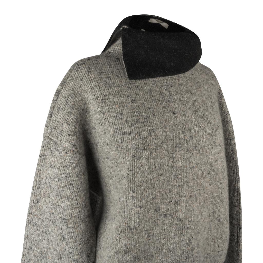 Guaranteed authentic Celine over sized turtleneck sweater.
Beautiful heathered gray.
Split turtleneck turns down to reveal solid black side.
Drop shoulder with slightly longer hem at rear.
Ribbed at cuff and hem.
Fabric is wool, polyester, nylon and