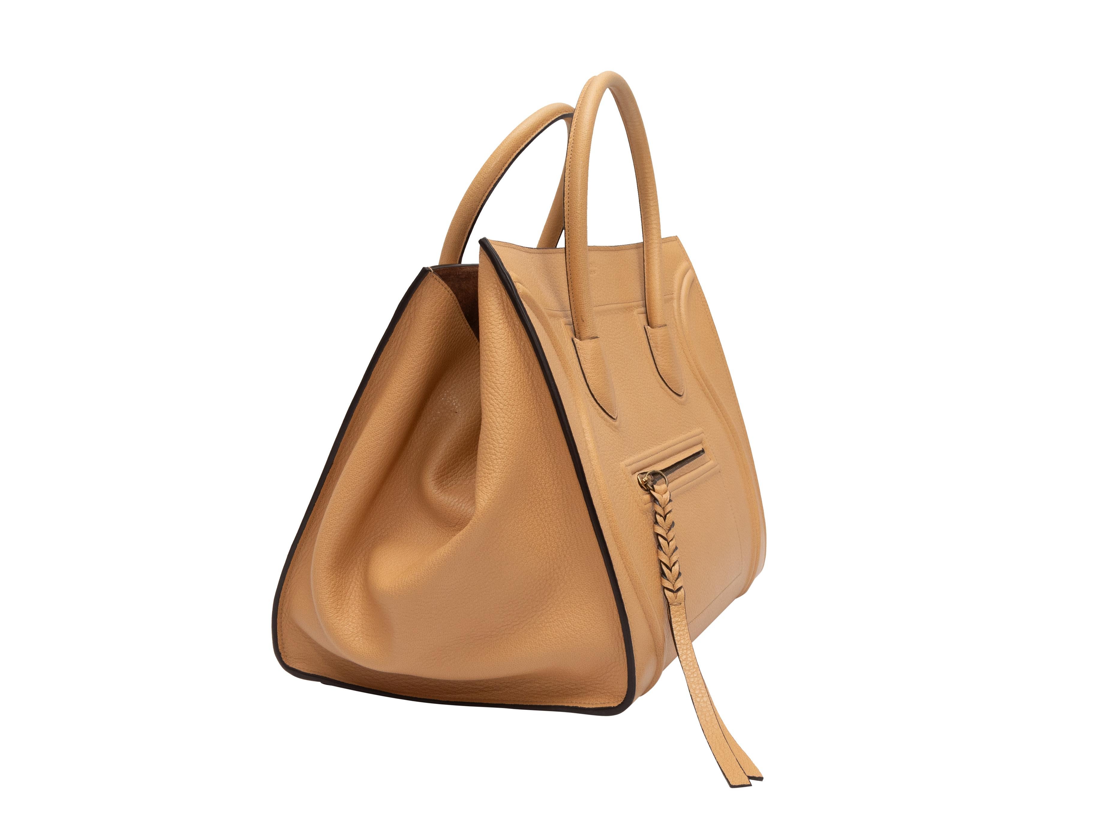 Product Details: Tan Celine Leather Phantom Luggage Bag. The Phantom bag features a leather body, gold-tone hardware, an interior zip pocket, a front zip closure pocket, dual rolled top handles, and a top closure. 11.5