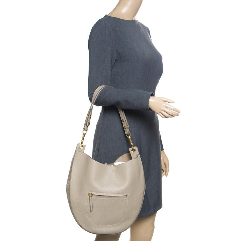 Featuring a chic and fabulous style, this Celine hobo is distinctive and very modern. Crafted from leather, the bag features a rounded shape, a front pocket and a single handle. It comes equipped with a spacious suede-lined interior for your