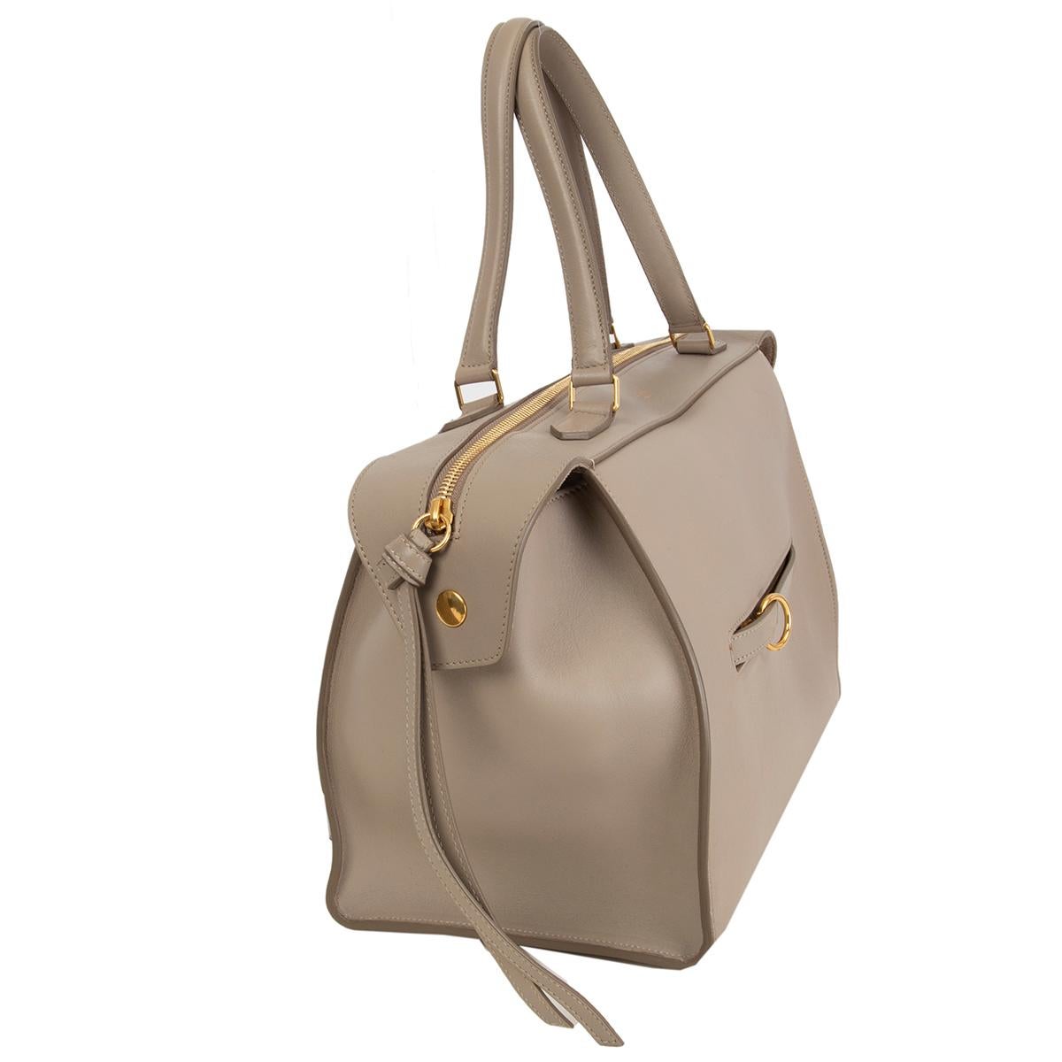 Céline 'Ring' handbag in taupe calfskin with a ring zip pocket at front featuring gold-tone hardware. Opens with a zipper on top and is lined in taupe suede with one zip pocket against the back and two slit pockets attached. Has been carried and is
