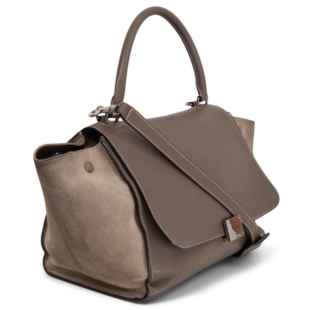 100% authentic Céline Trapeze shoulder bag in taupe grained calfskin and light taupe suede side parts. One zipper pocket on the back. Opens with zipper on top. Lined in brown lambskin with two  slit pocket against the back. Has been carried with
