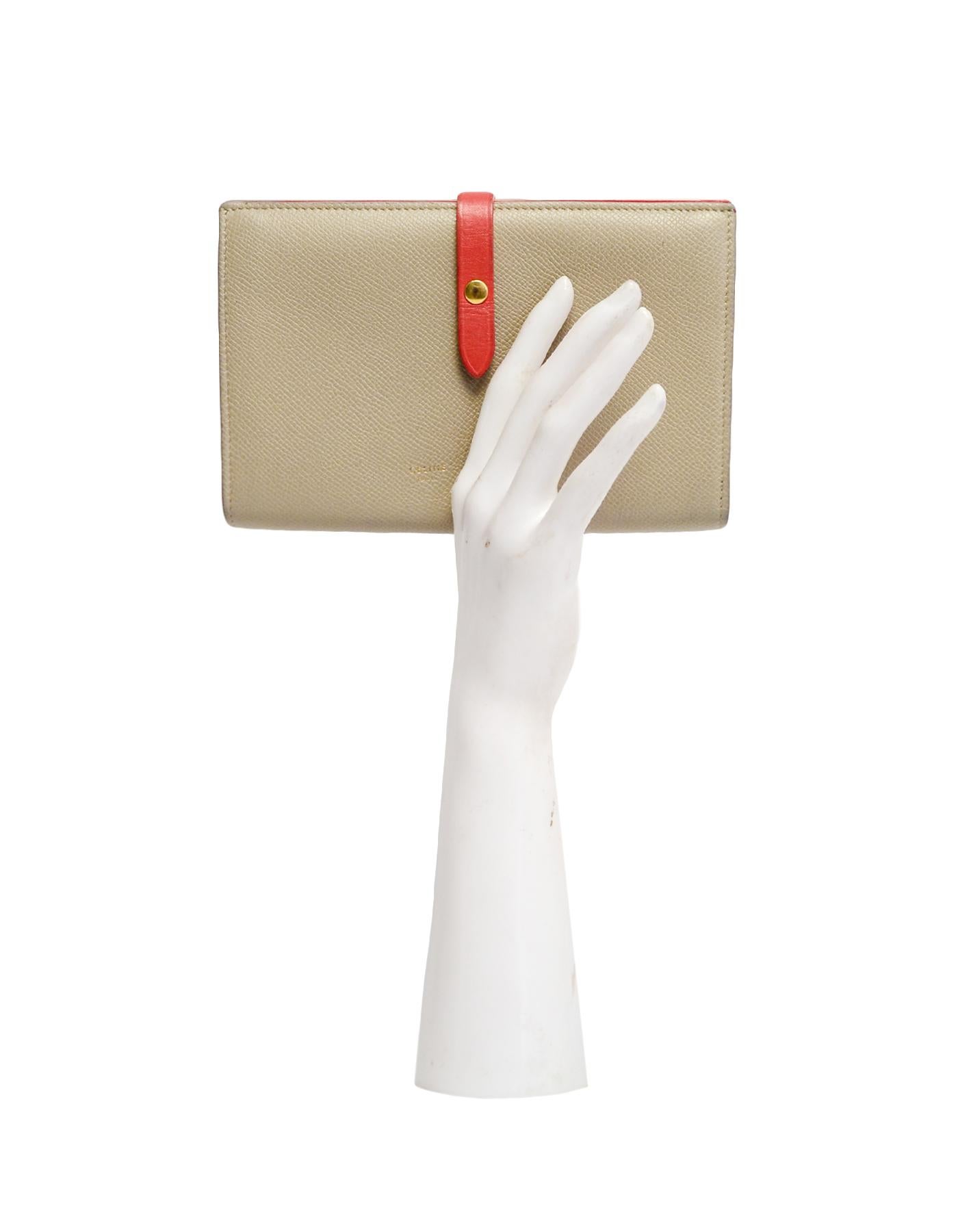Celine Taupe/Red Grained Calfskin Large Multifunction Strap Wallet rt $810

Made In: Italy
Color: Taupe, red
Hardware: Goldtone hardware
Materials: Calfskin leather
Lining: Taupe suede lining
Closure/Opening: Strap with snap closure
Exterior