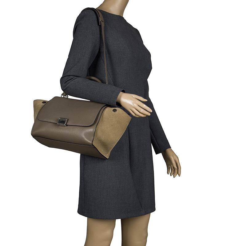 Featuring a chic, yet luxurious style, this Celine bag is distinctive. Crafted from leather and suede, this tote features signature flappy wings, silver tone hardware and a zip pocket at the rear. The front flap of the taupe two tone opens to a