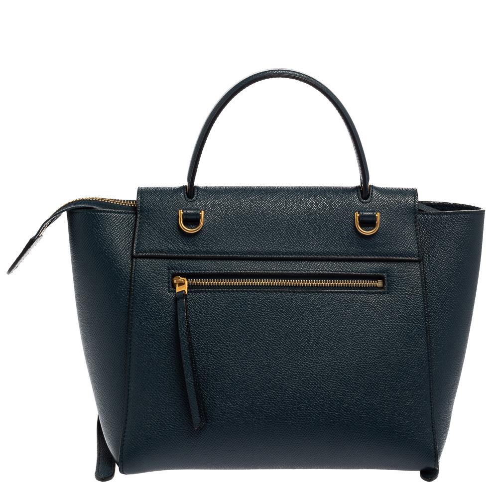 Bags from Celine are symbols of excellent craftsmanship and timeless design. This teal blue creation has been crafted from leather and styled with a front tuck-in flap and belt details. It flaunts a single top handle and a spacious suede interior