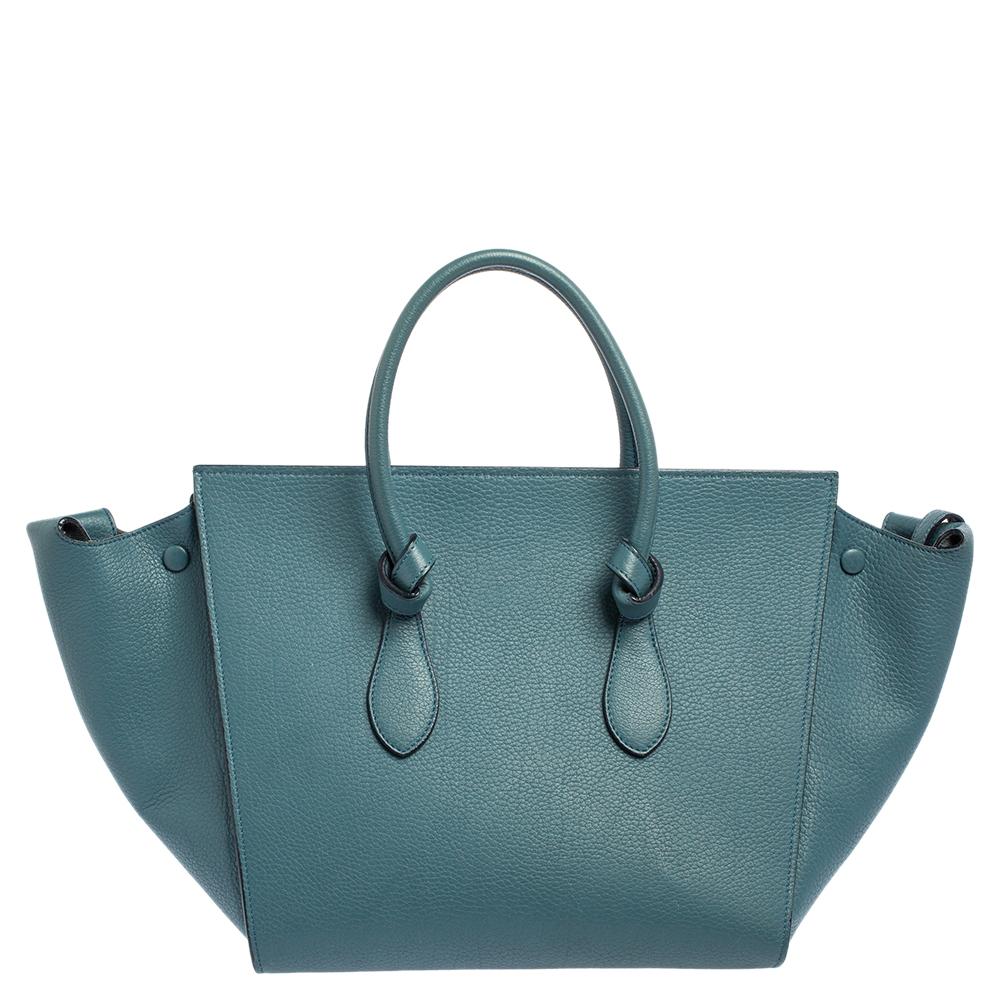Diese Krawatten-Tasche von Celine ist eine wunderbare Mischung aus Mode und Funktion. Die fachmännisch aus Leder gefertigte Tasche ist in einem schönen blaugrünen Farbton gehalten und verfügt über zwei Griffe mit Knotendetails und Metallnieten zum