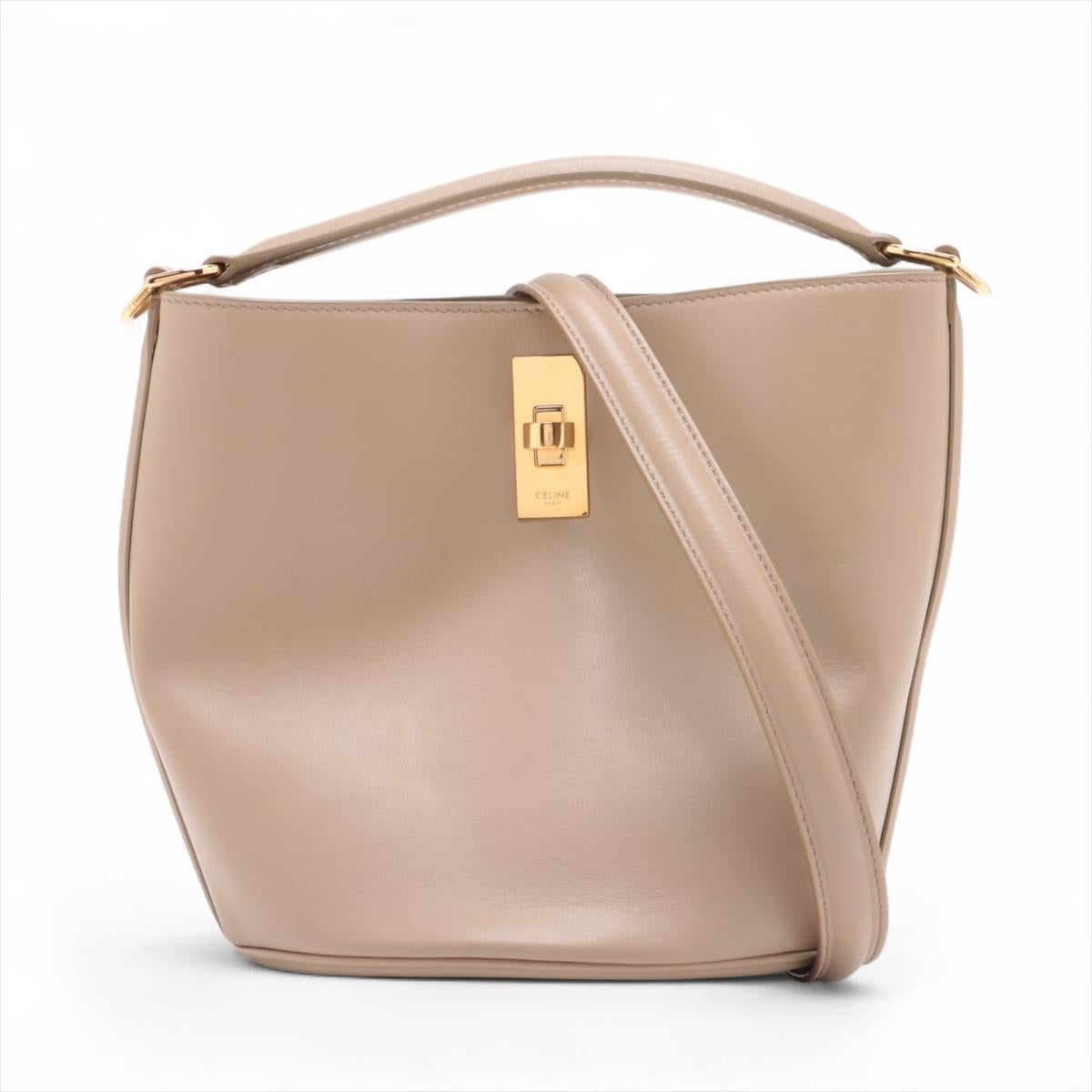 Le sac à bandoulière Teen Bucket 16 de Celine, de couleur beige, est un accessoire sophistiqué et polyvalent conçu en cuir de haute qualité. Conçu avec une esthétique épurée et minimaliste, il est doté d'un intérieur spacieux qui offre suffisamment