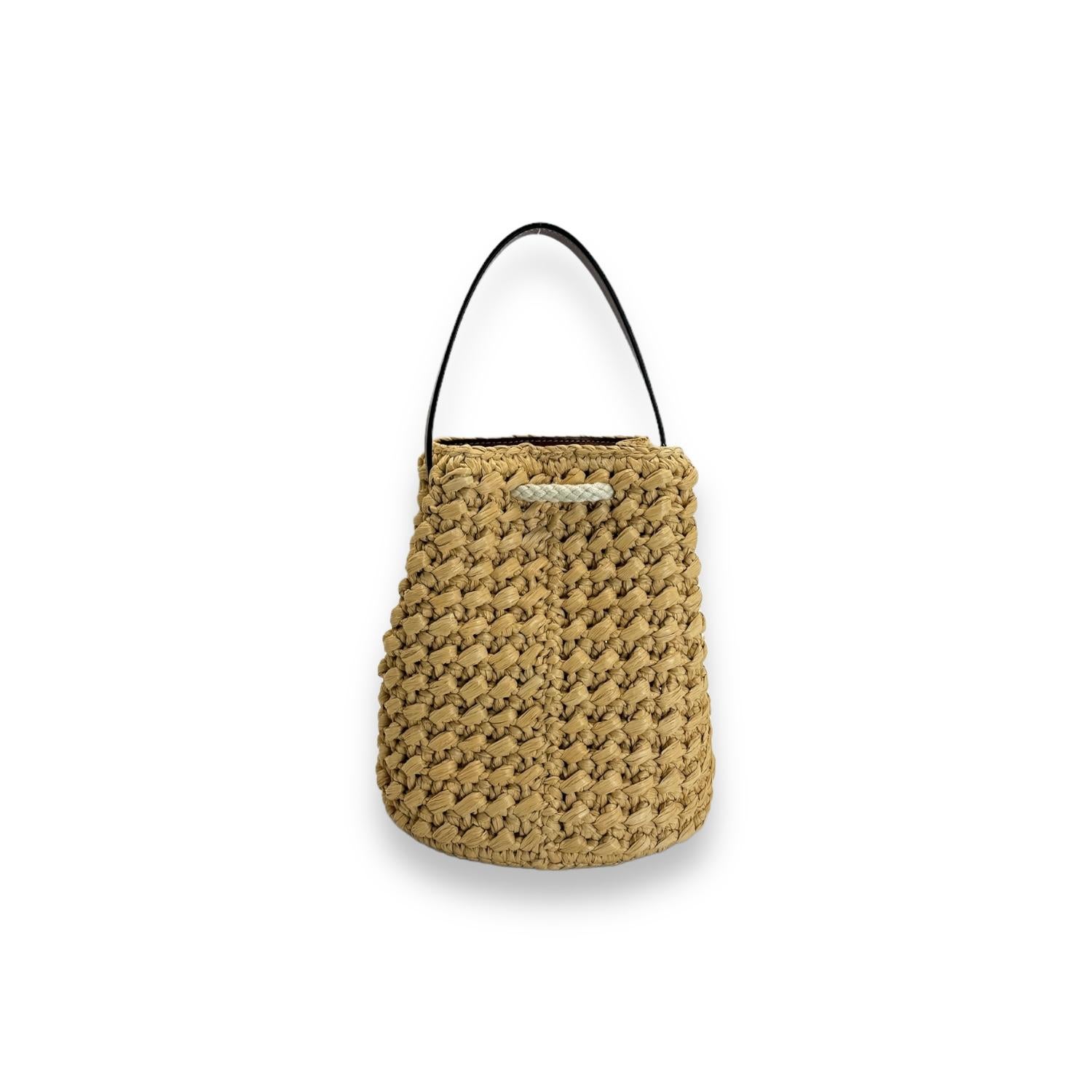 Get ready for summer with the Celine Teen Drawstring Raffia Bucket Bag! With a mix of raffia and calfskin leather, this bag is both stylish and durable. The drawstring closure makes it easy to access your belongings while the 5