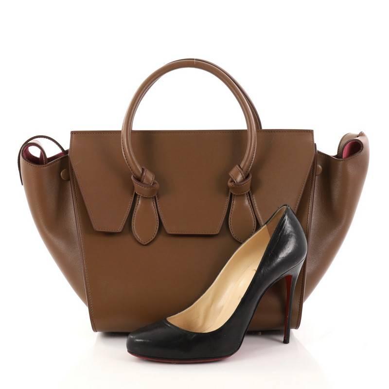 This authentic Celine Tie Knot Tote Smooth Leather Mini is an absolute must-have for serious fashionistas. Crafted from brown smooth leather, this boxy tote features dual-rolled leather handles with signature knot accents, protective base studs,