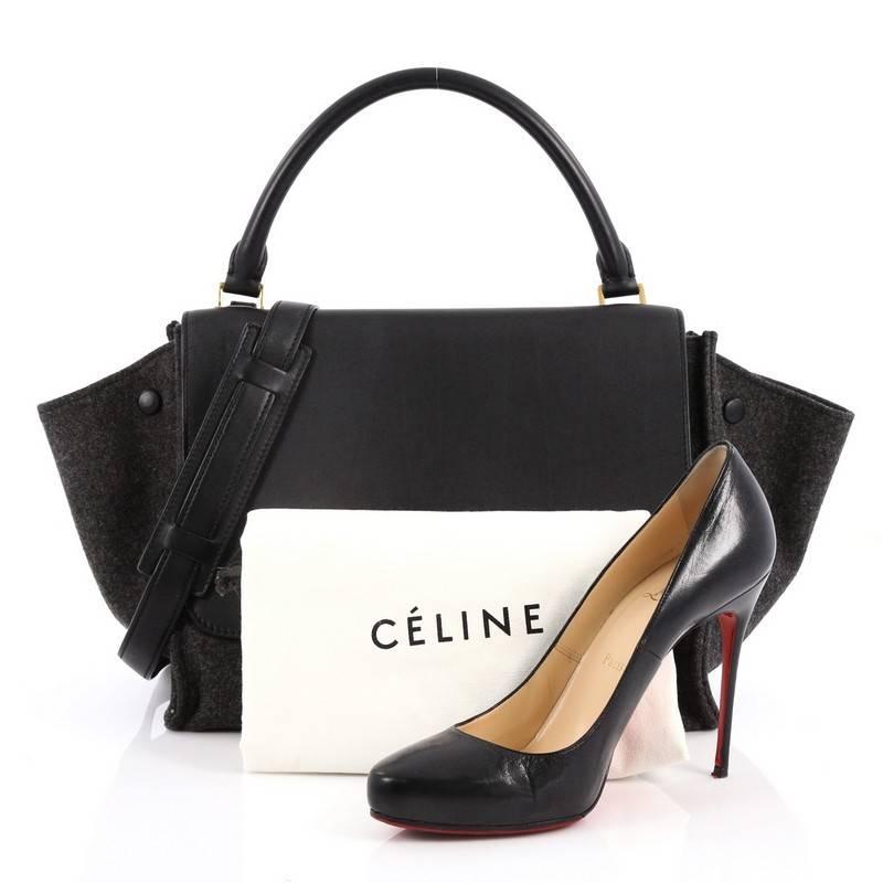 This authentic Celine Trapeze Handbag Leather and Felt Medium is every fashionista's dream. Crafted in black leather and dark gray felt, this classic bag features a top handle, exterior back pocket and gold-tone hardware accents. Its square